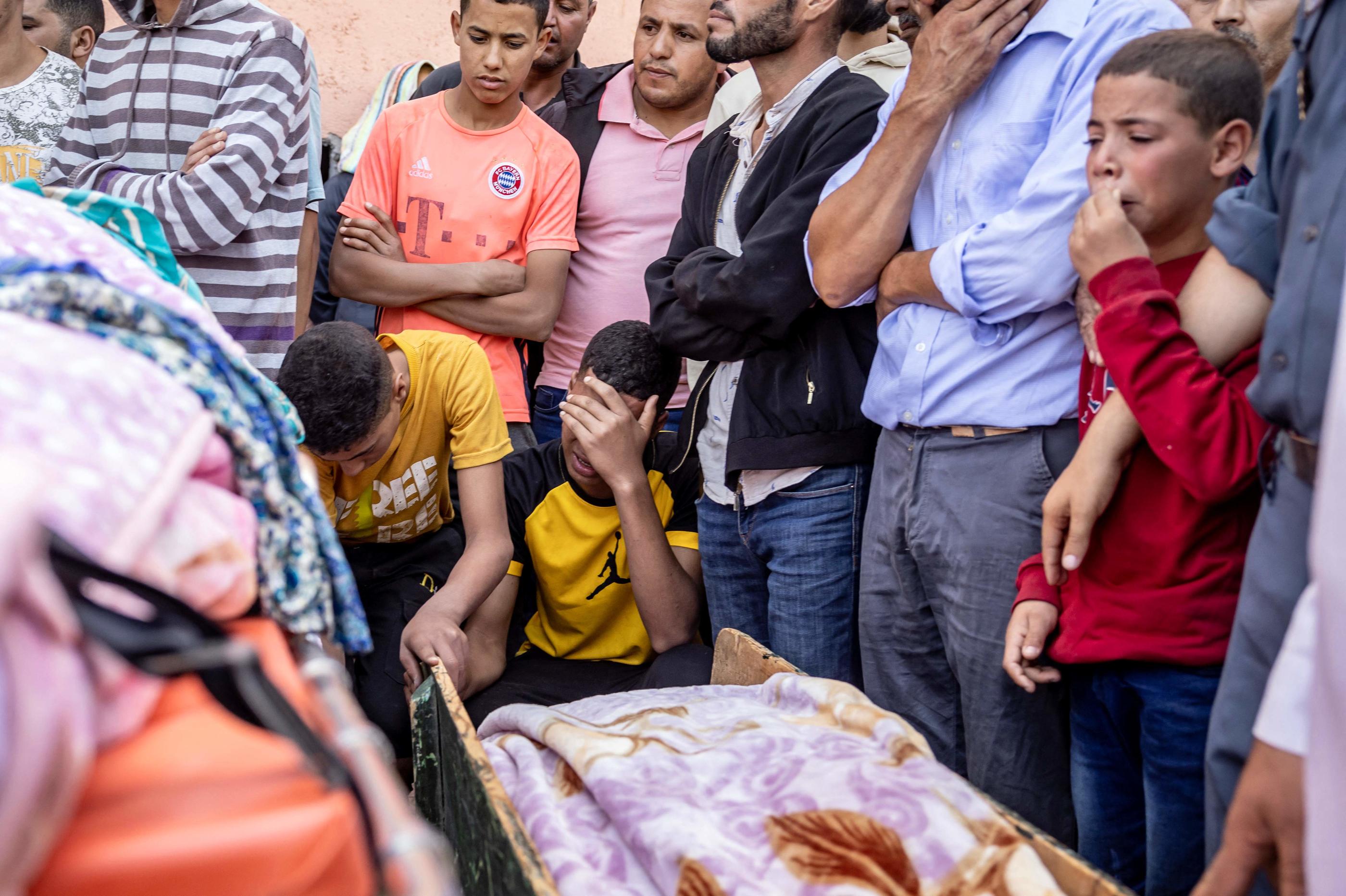 Des personnes pleurent devant le corps d'une victime tuée lors d'un tremblement de terre à Moulay Brahim, dans la province d'Al Haouz (Photo de FADEL SENNA / AFP)