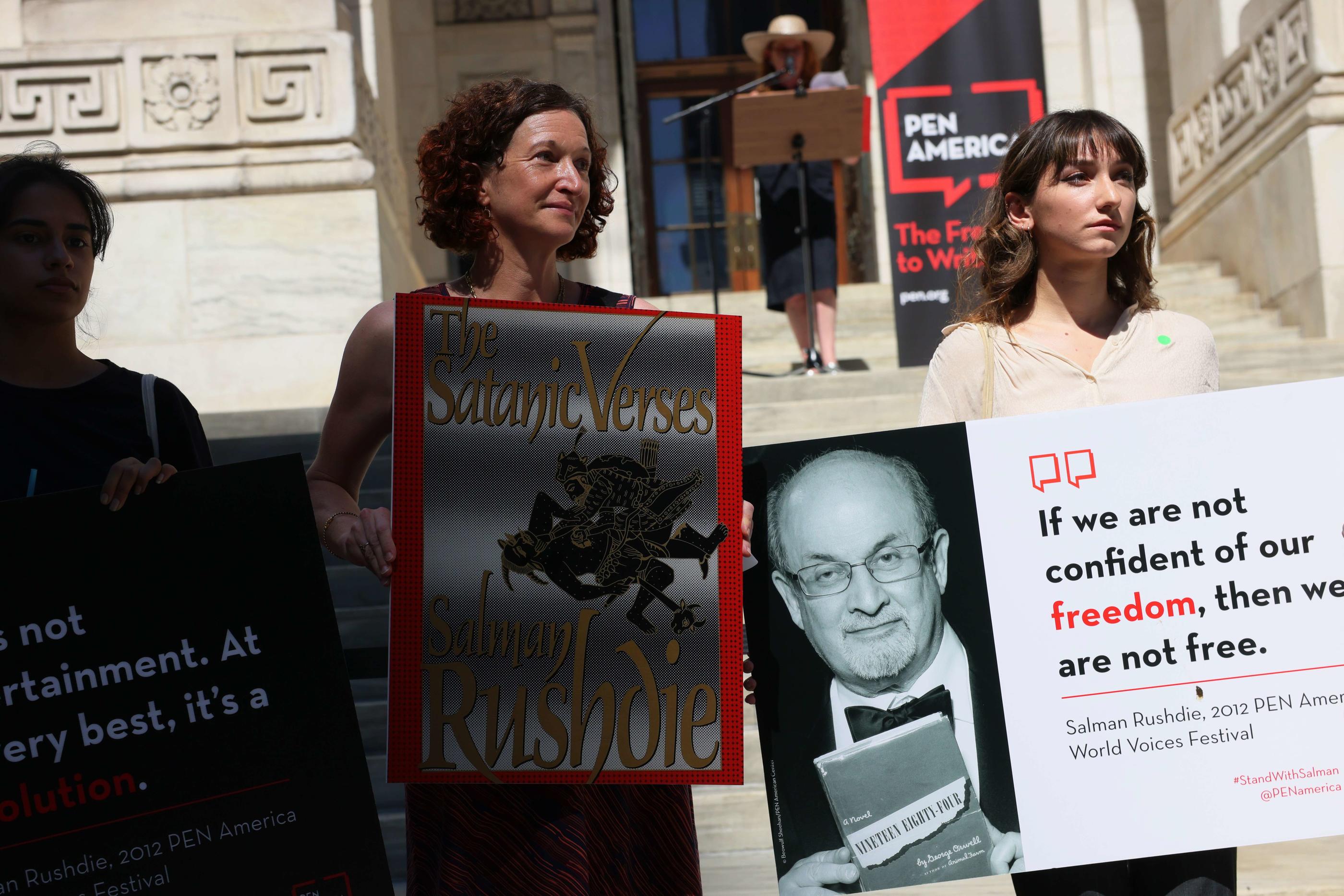 Des manifestants affichent le visage de Salman Rushdie sur une pancarte lors d'un rassemblement en hommage à l'oeuvre littéraire de l'écrivain, à New York, le 19 août. AFP/Getty Images/Michael M. Santiago