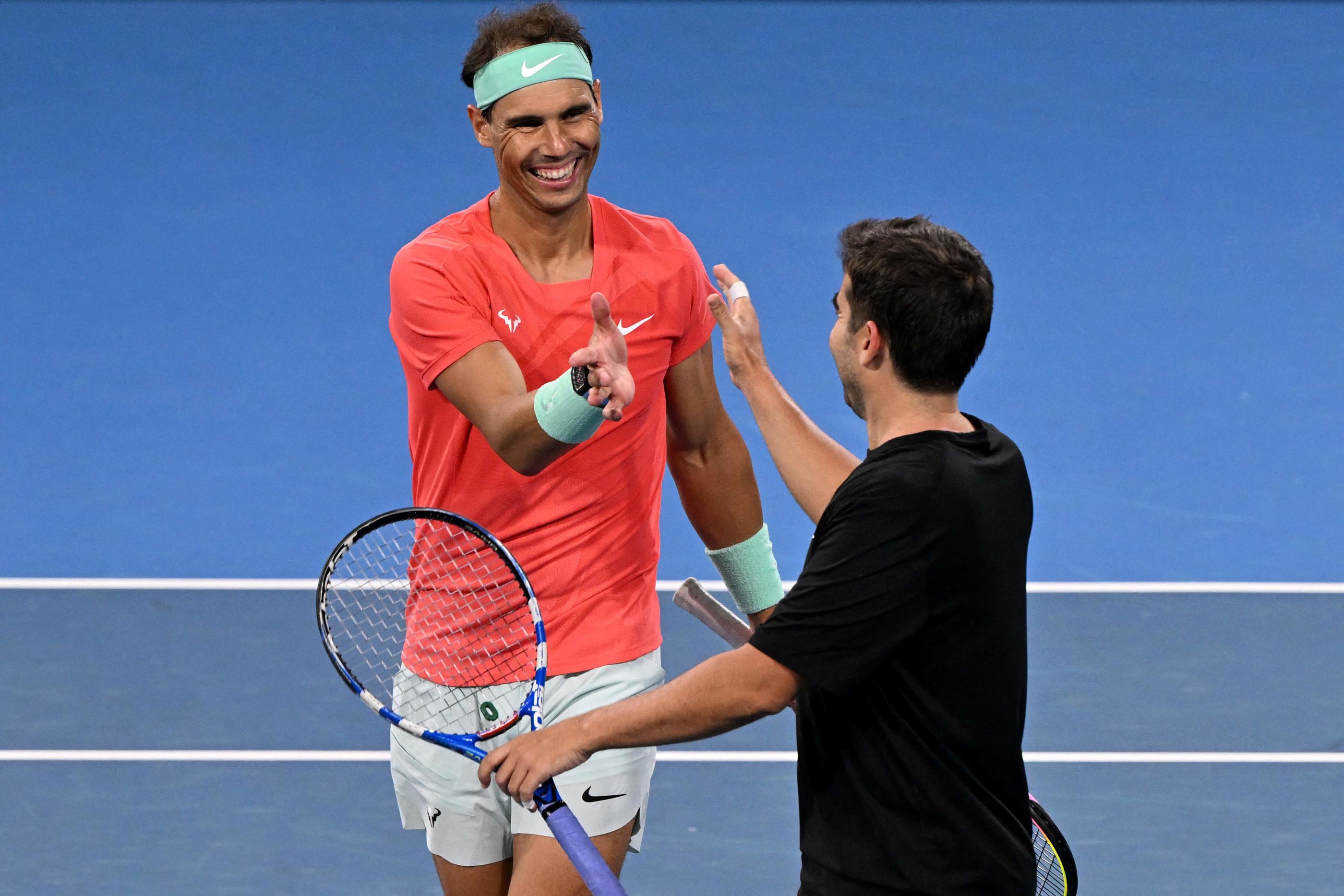 Tout sourire, Rafael Nadal tape dans la main de son entraîneur Marc Lopez, avec lequel il avait remporté la médaille d'or aux JO 2016.