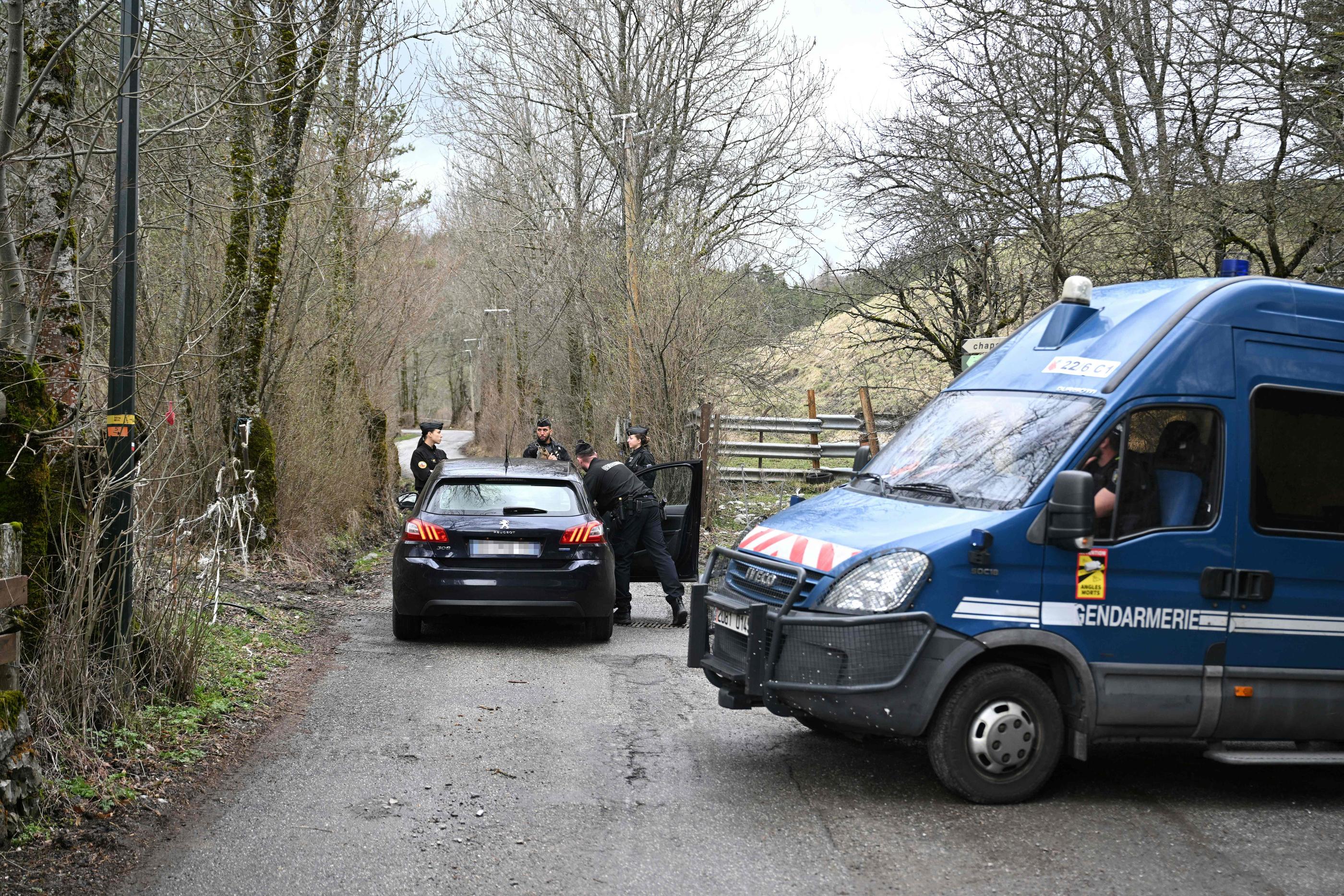 Des gendarmes français inspectent une voiture sur la route menant au hameau du Haut-Vernet. AFP/Nicolas Tucat