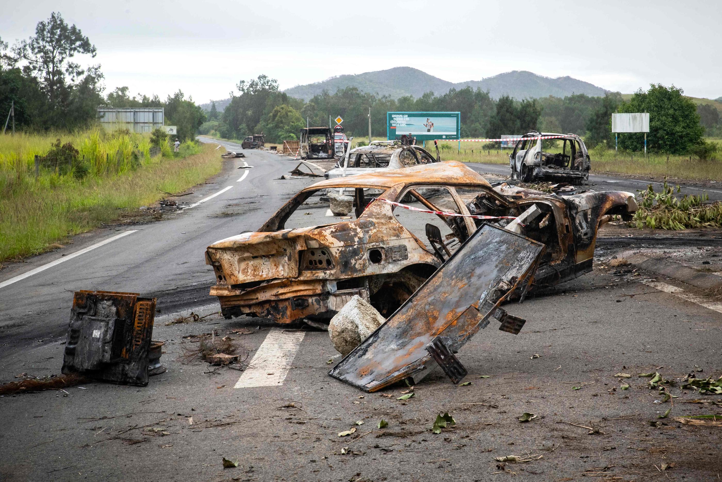 L'axe entre Nouméa et l'aéroport international est jonché de carcasses de véhicules brûlés et de déchets érigés pour bloquer la route par les émeutiers. AFP/Delphine Mayeur