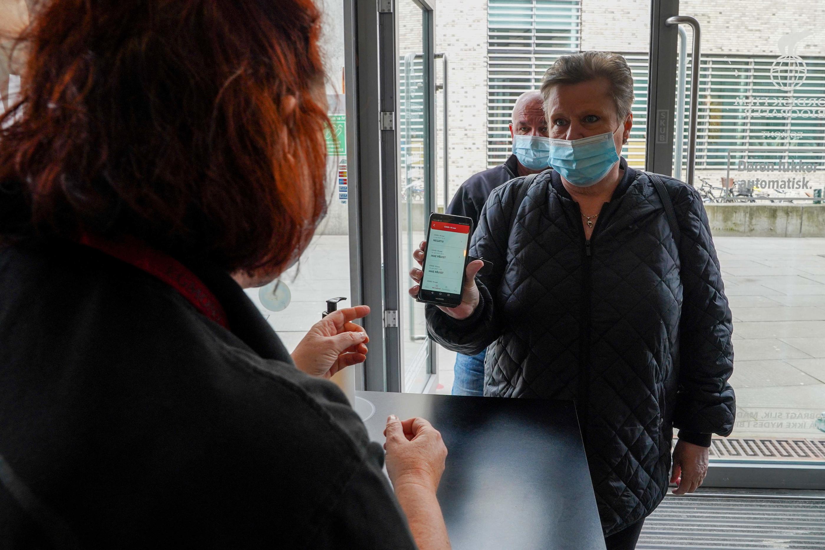Une cliente montre son "coronapas", un pass sanitaire en vigueur au Danemark, à l'entrée d'un cinéma. AFP