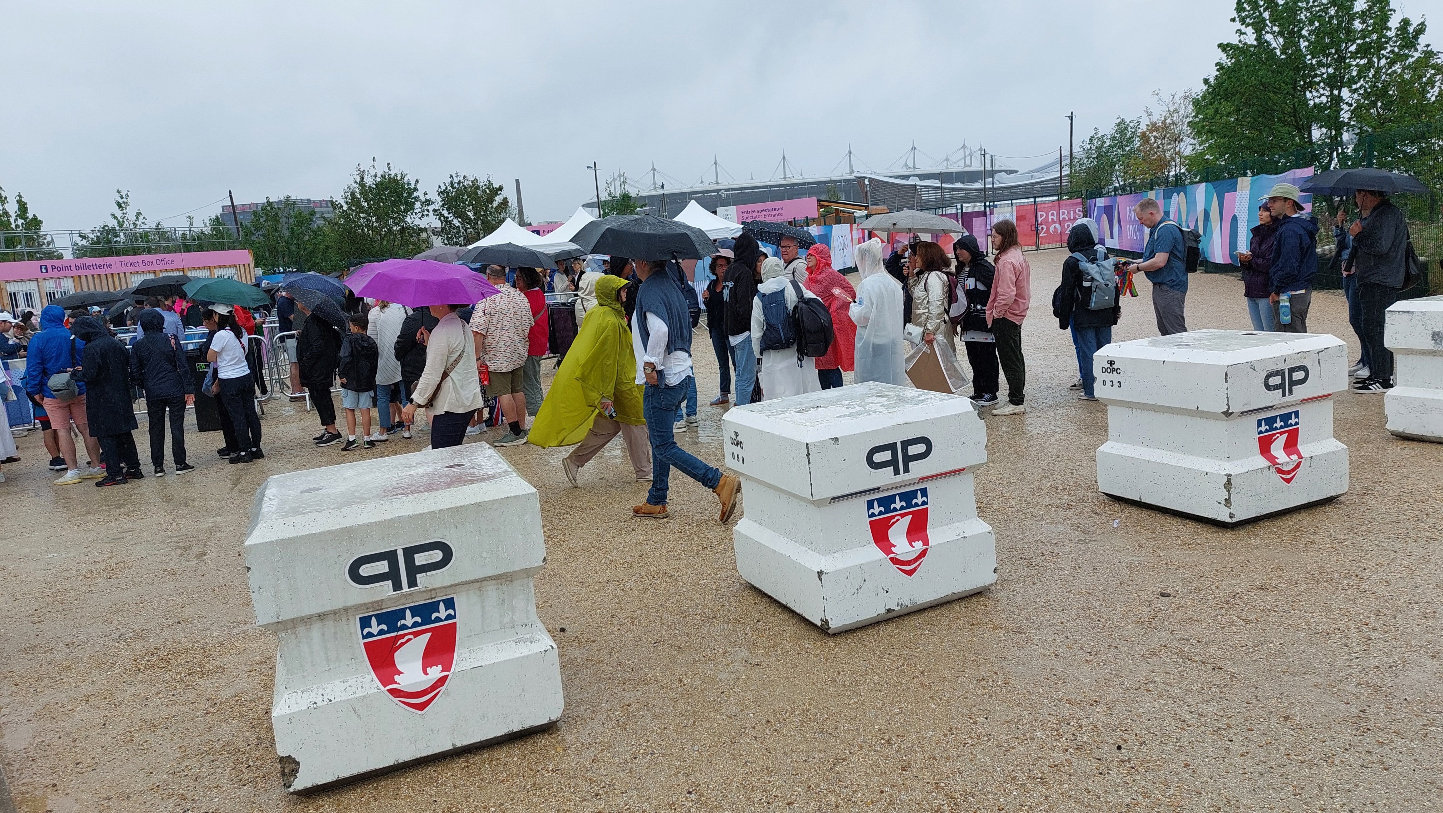 Saint-Denis, ce samedi.  Accueilli à l'arrière du centre aquatique olympique , le public découvre un décor austère, à peine égayé par les blocs anti-intrusion aux couleurs de la préfecture de police de Paris. LP/Claire Guédon