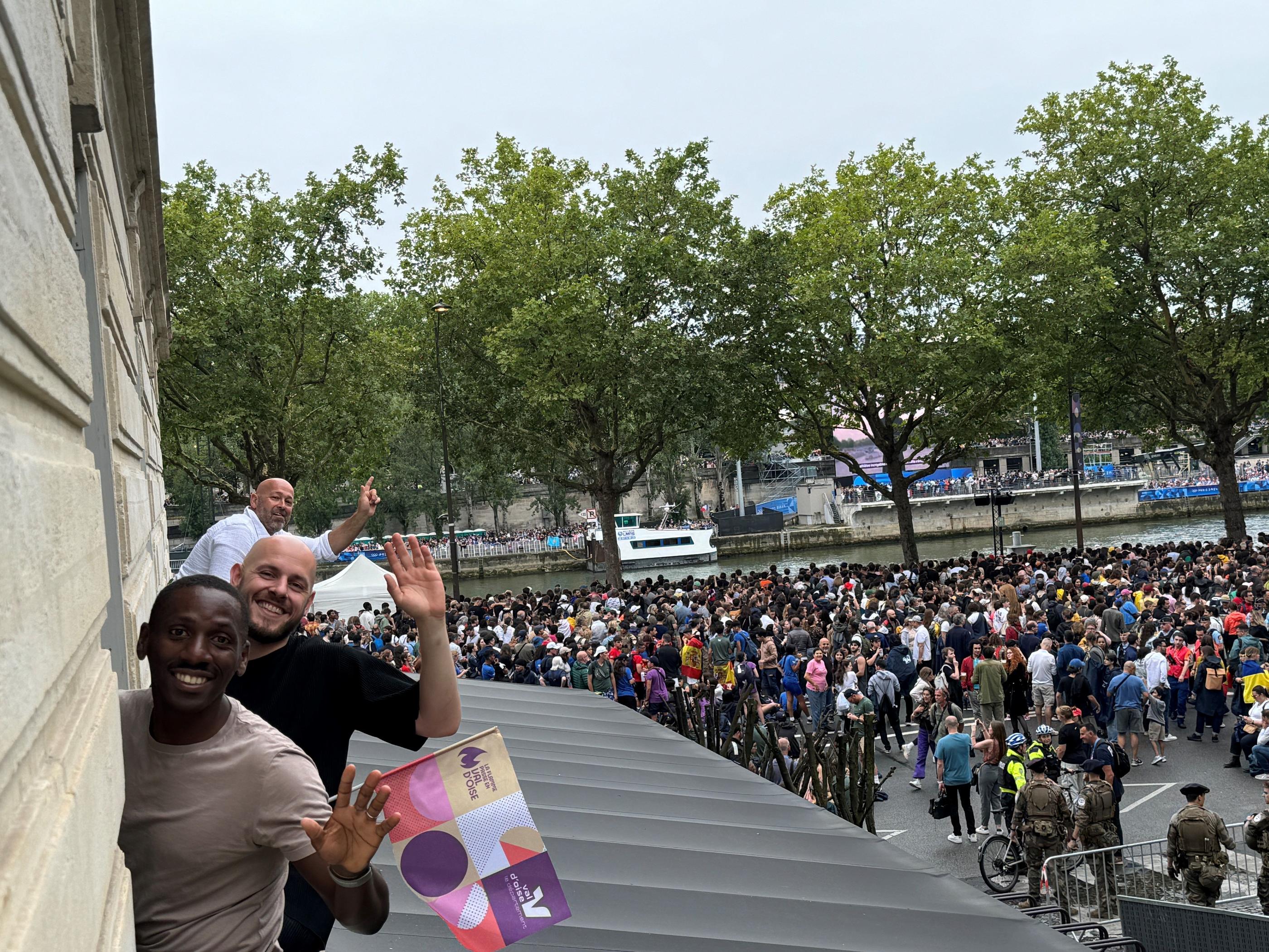 Paris, XVIe arrondissement, ce vendredi. La famille de Manou profite d'être à l'abri de la pluie pour regarder passer la parade fluviale au pont de l'Alma. LP/Delphine Denuit