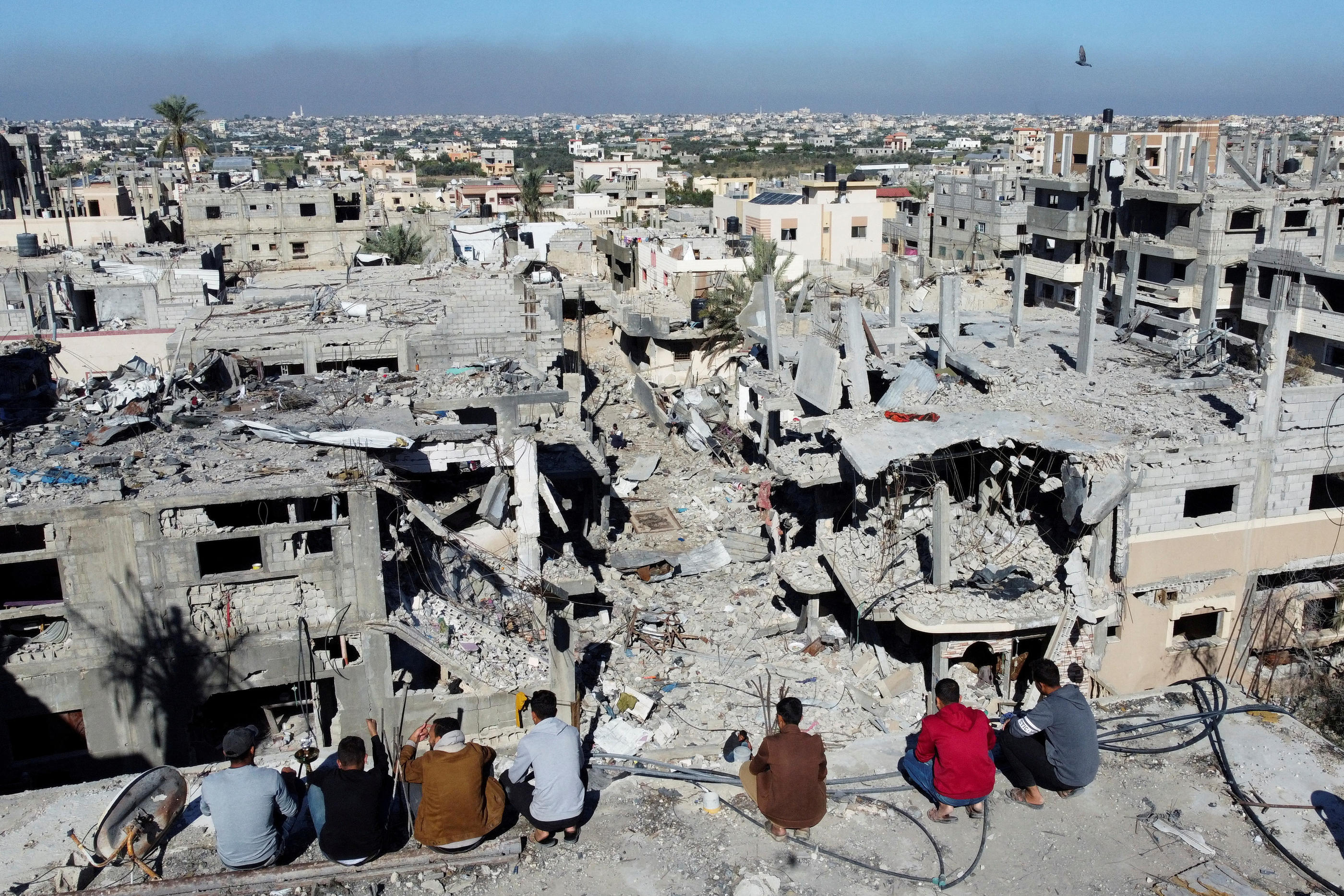 Des Palestiniens regardent les maisons détruites lors des frappes israéliennes pendant le conflit, dans le cadre de la trêve temporaire entre Israël et le groupe islamiste palestinien Hamas, au camp de réfugiés de Khan Younis, dans le sud de la bande de Gaza, le 29 novembre 2023. REUTERS/Mohammed Salem