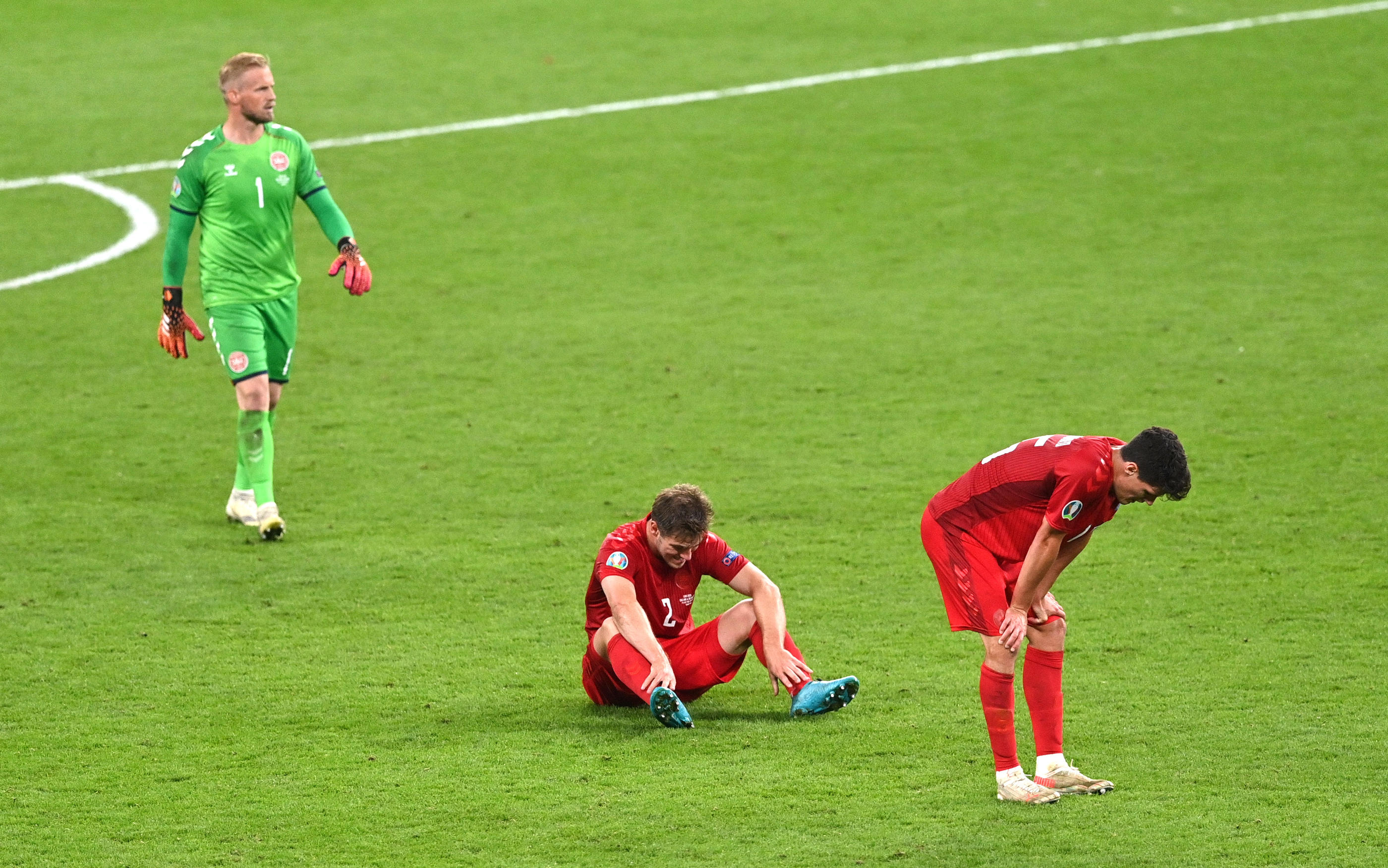 Les Danois Kasper Schmeichel, Christian Norgaard et Joachim Andersen après leur défaite en demi-finale de l'Euro 2021. REUTERS/Justin Tallis