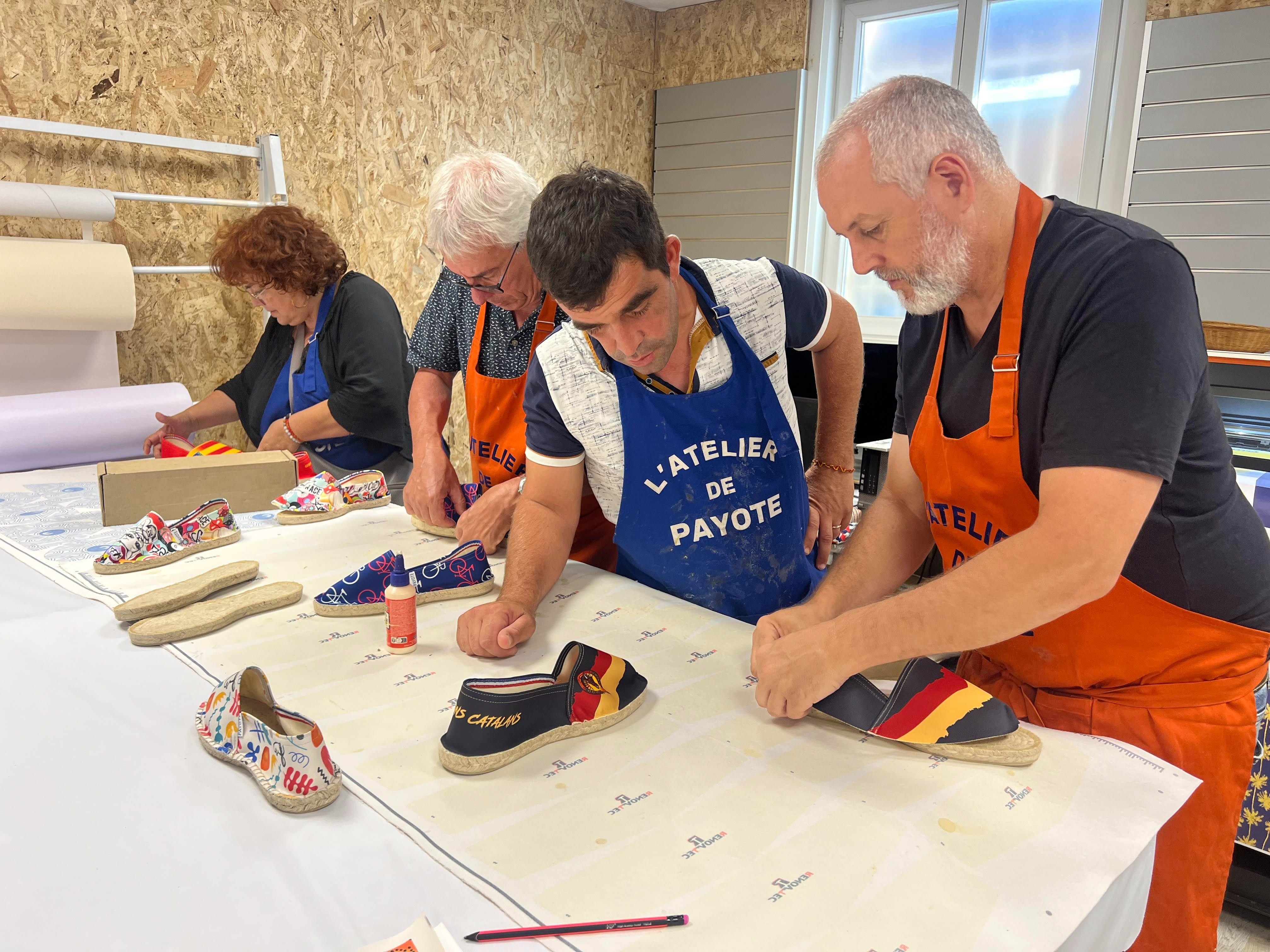 Le chef d'atelier de Payote, Mourad (à droite), explique ici l'étape la plus délicate, celle de l'encollage du tissu sur la semelle de corde. LP/Christian Goutorbe