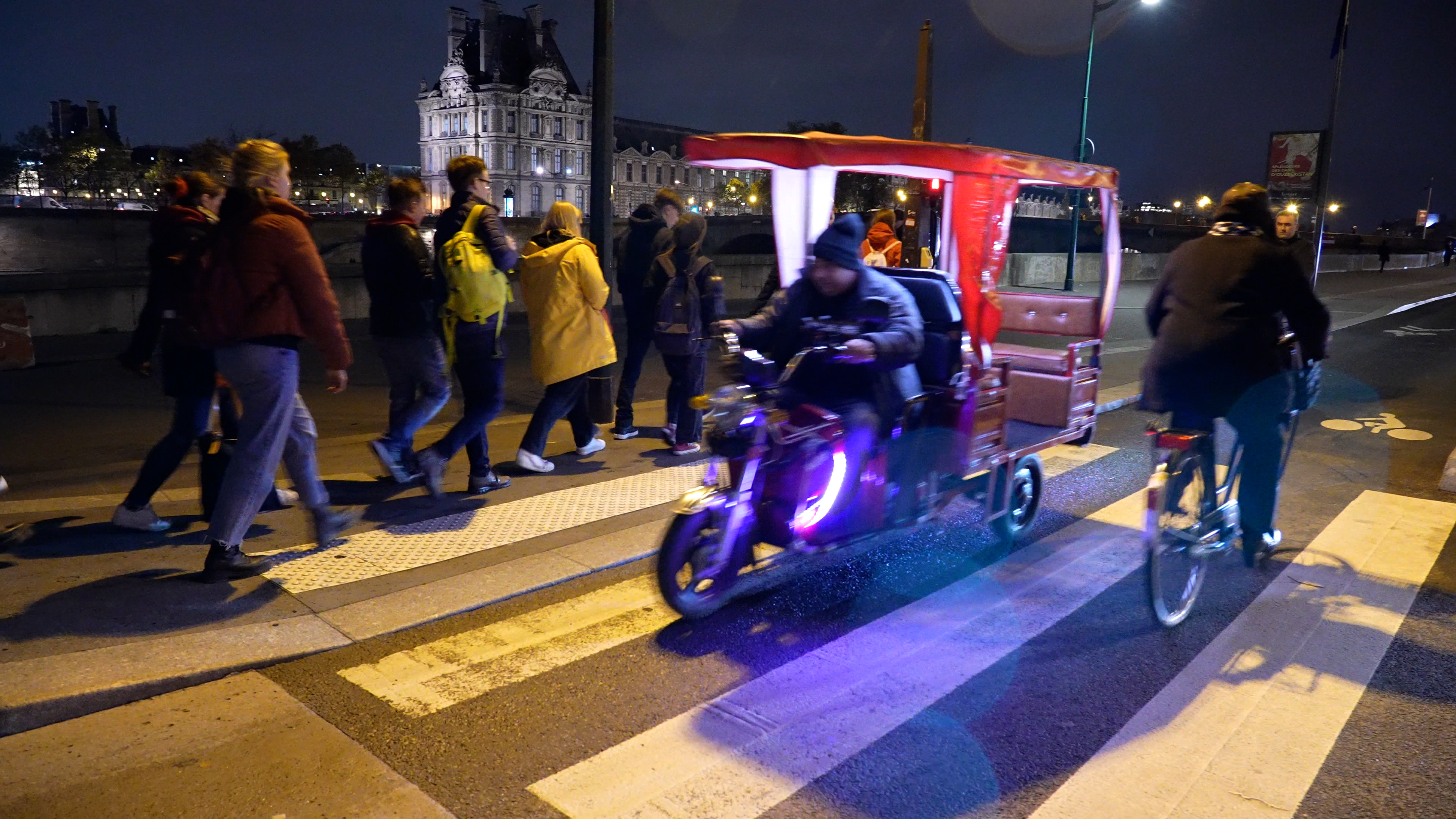 Un tuktuk roule sur une piste cyclable de la capitale