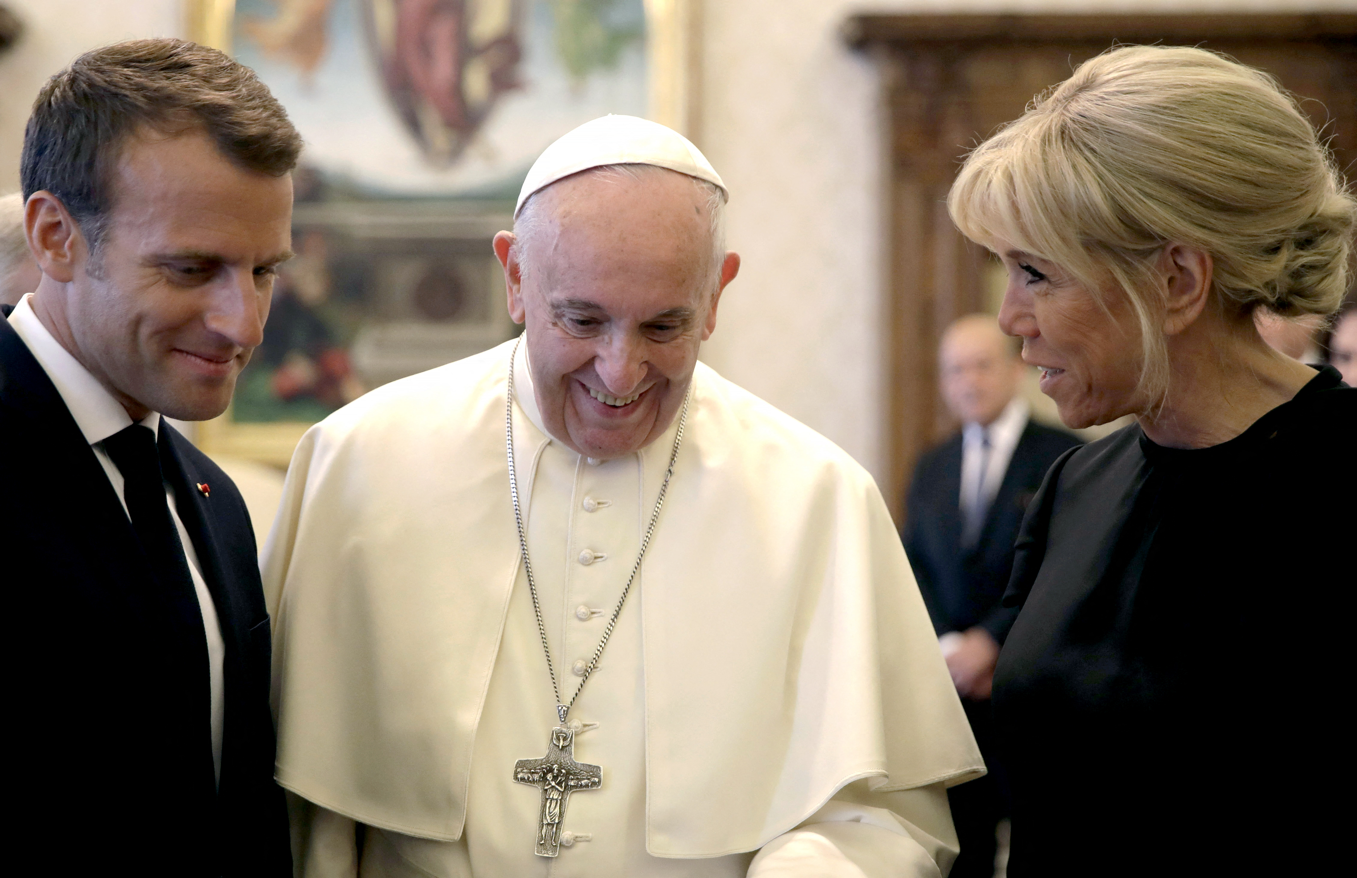 Le pape François, le 26 juin 2018, entre Emmanuel et Brigitte Macron dans la grande bibliothèque du Vatican pour une audience privée. AFP/Pool/Alessandra Tarantino