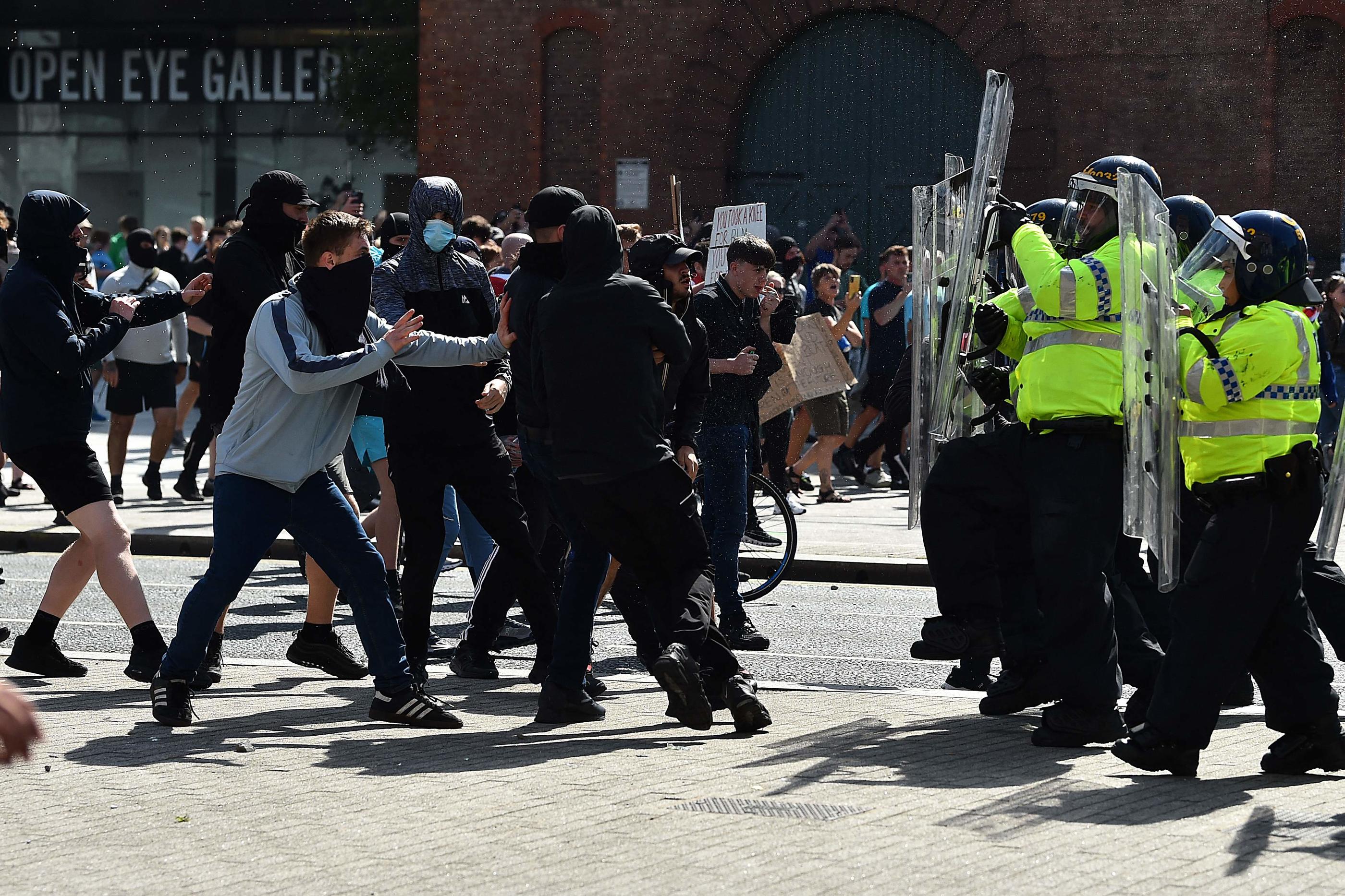 Des policiers face à des personnes participant à la manifestation "Enoug is Enough", le 3 août, à Liverpool (Angleterre). AFP/Peter Powell