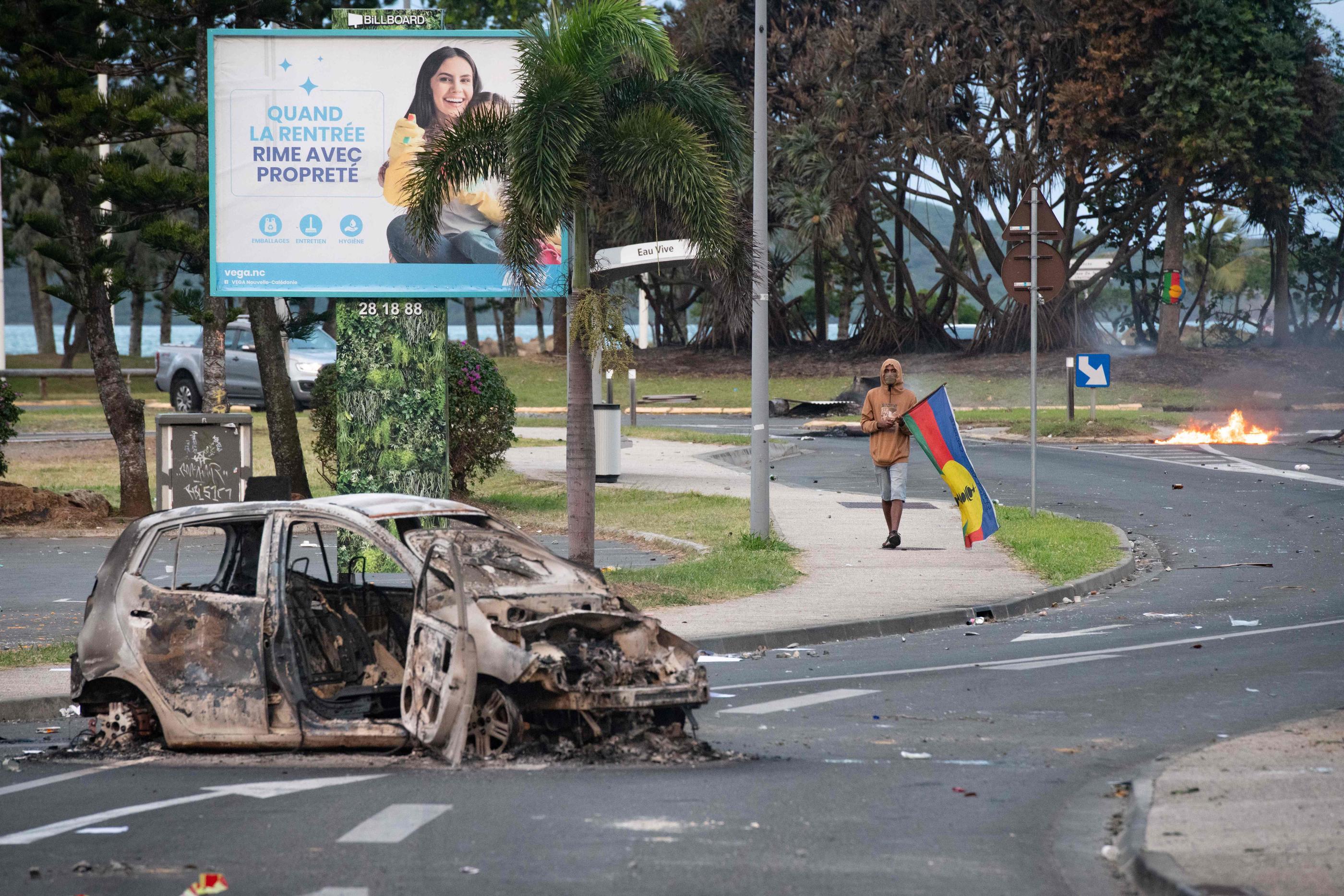 Une voiture brûlée à Nouméa (Nouvelle-Calédonie), après une nuit d'affrontements, le 14 mai 2024. AFP/Delphine Mayeur