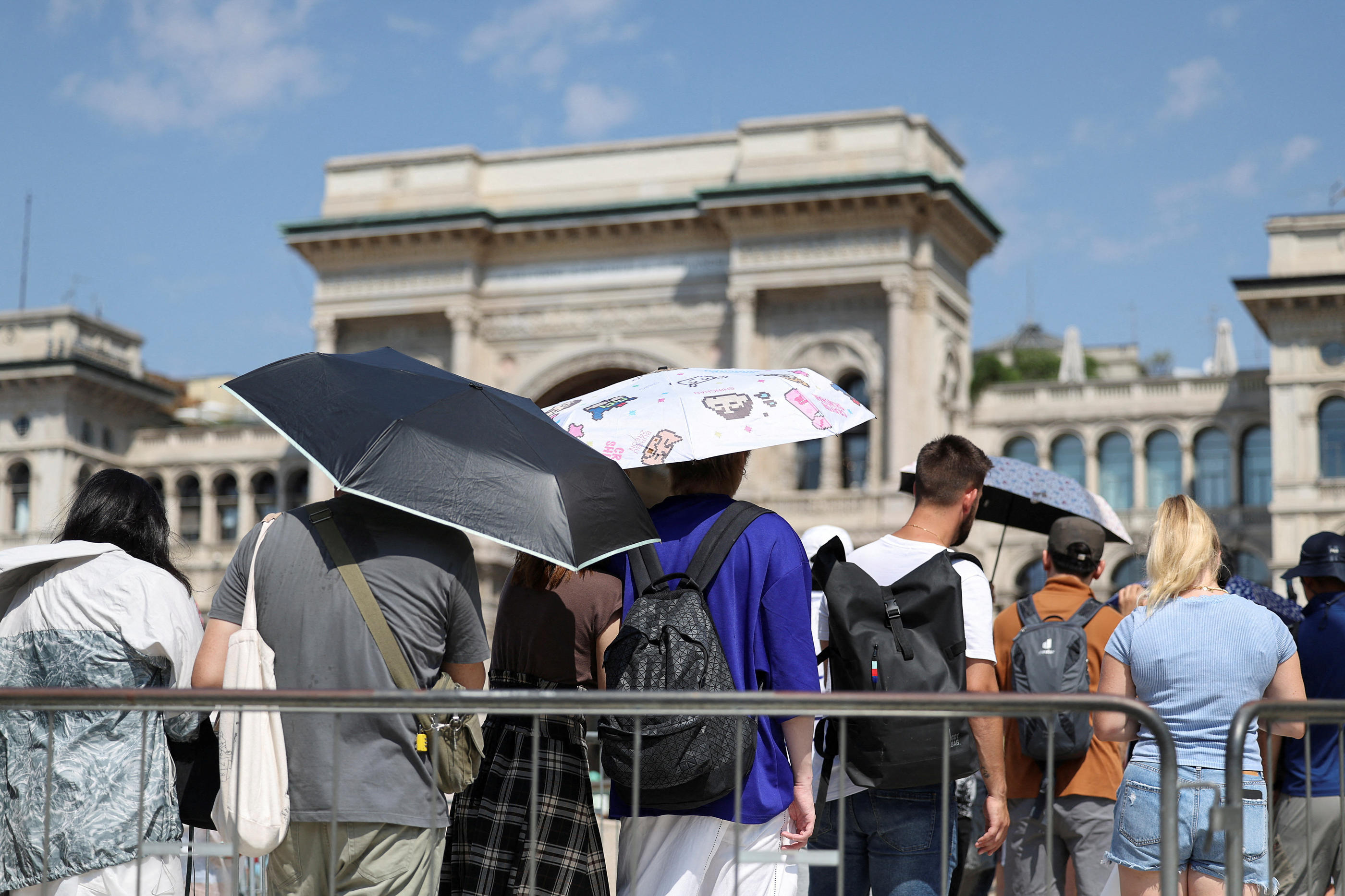 Les visiteurs du Duomo se sont abrités du soleil sous des parapluies. Reuters/Claudia Greco