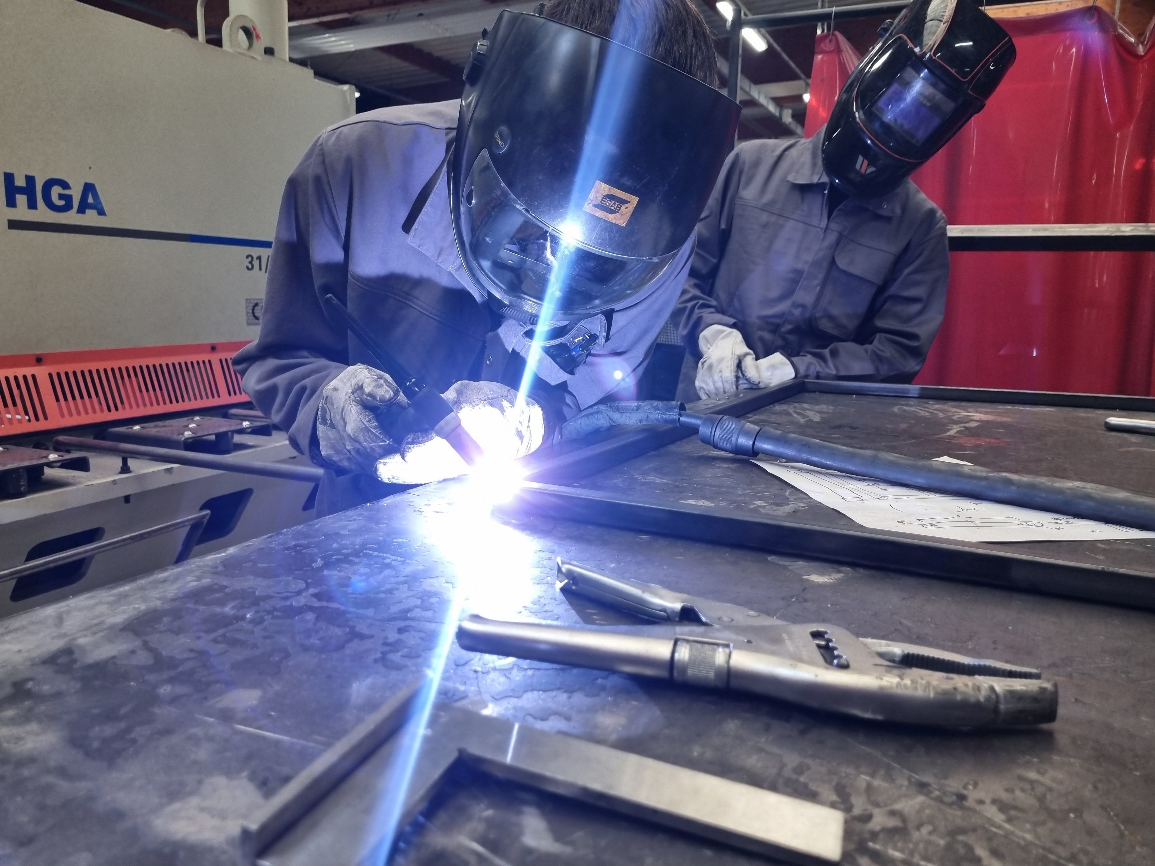 Derrière la "cagoule", Anthony, en deuxième année de CAP chaudronnerie chez O'Tech, pratique une soudure sur l'armature d'une devanture de bar commandée par un client de l'école.