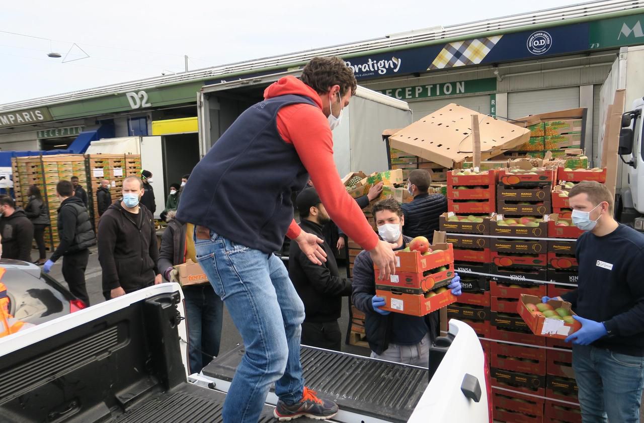 <b></b> Marché de Rungis, mardi 7 avril. Ici, des bénévoles d’Orly récupèrent une partie des 50 tonnes de mangues et ananas offertes par le grossiste Bratigny.