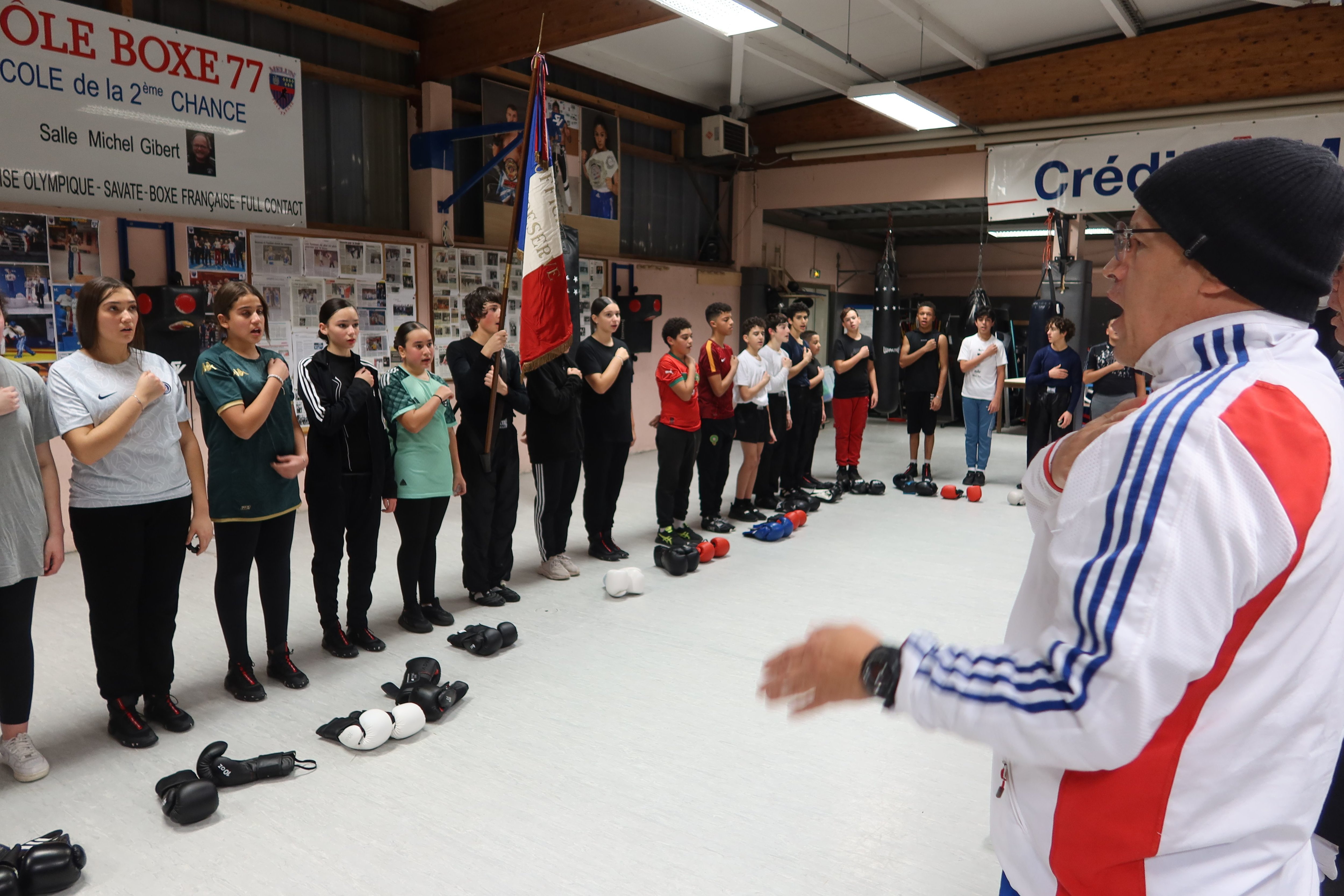 Melun (Seine-et-Marne), le 8 novembre 2023. A la fin des cours, les jeunes boxeurs et boxeuses posent les gants et entonnent « la Marseillaise », la main sur le cœur, devant Momo (au 1er plan à droite). LP/Sophie Bordier