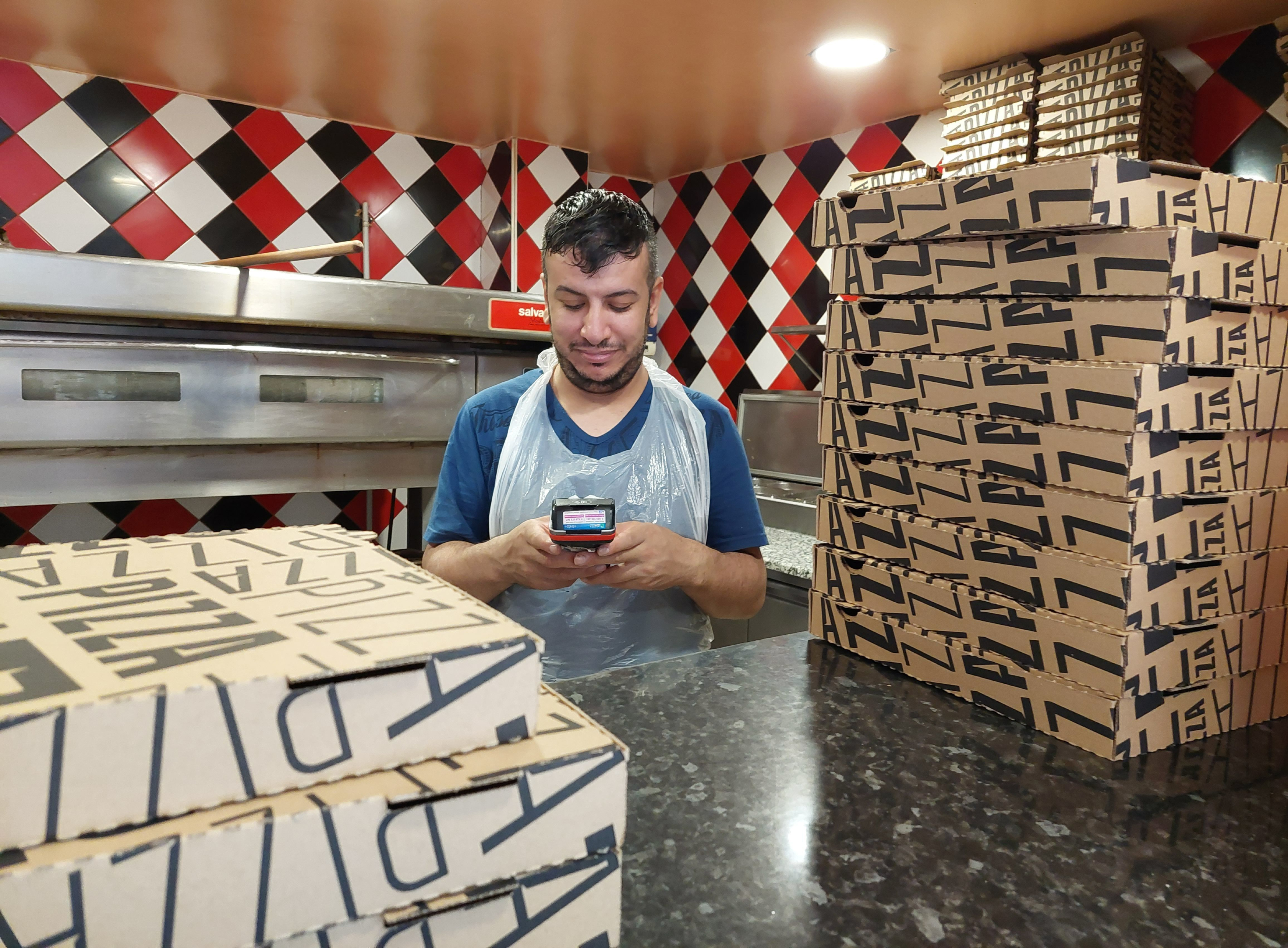 Ris-Orangis (Essonne), jeudi 24 août 2023. À cause des dysfonctionnements du réseau, Zied, employé de la pizzeria Andiamo Pronto Pizza, rencontre des problèmes avec le terminal de paiement, comme de nombreux commerces du quartier. LP/Florian Garcia