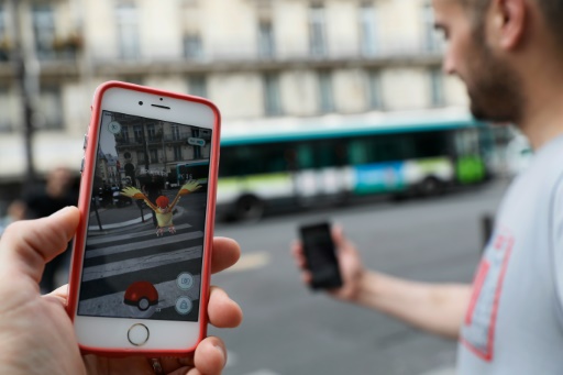 Dans les rues de Paris, un joueur s'apprête à attraper Roucoups pour l'ajouter à son Pokédex grâce à son smartphone. AFP/Thomas Samson