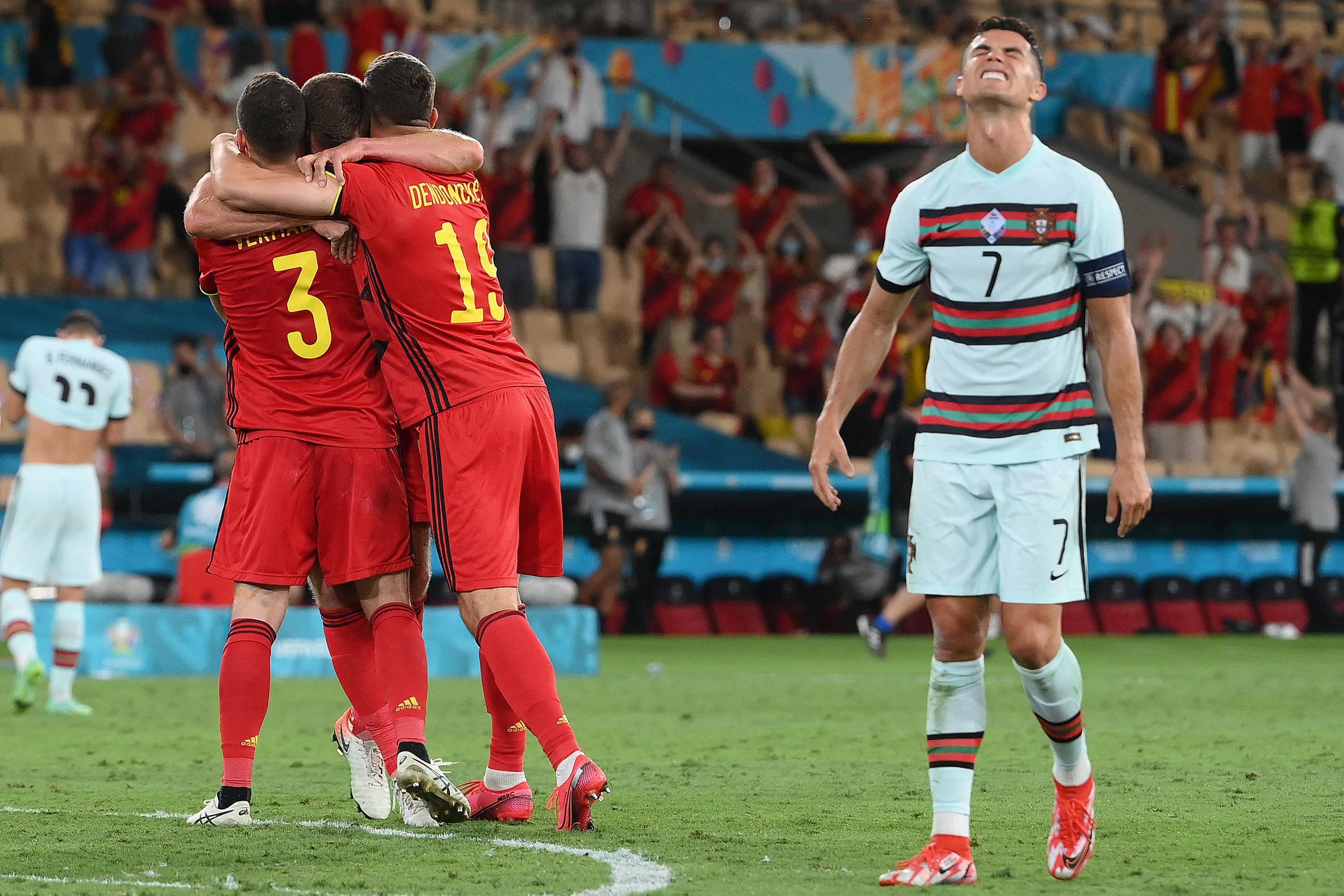 La joie des Belges contraste avec la déception de Cristiano Ronaldo (à droite), éliminé avec le Portugal par la Belgique en huitième de finale de l'Euro, le 27 juin 2021 à Séville. AFP/Lluis Gene