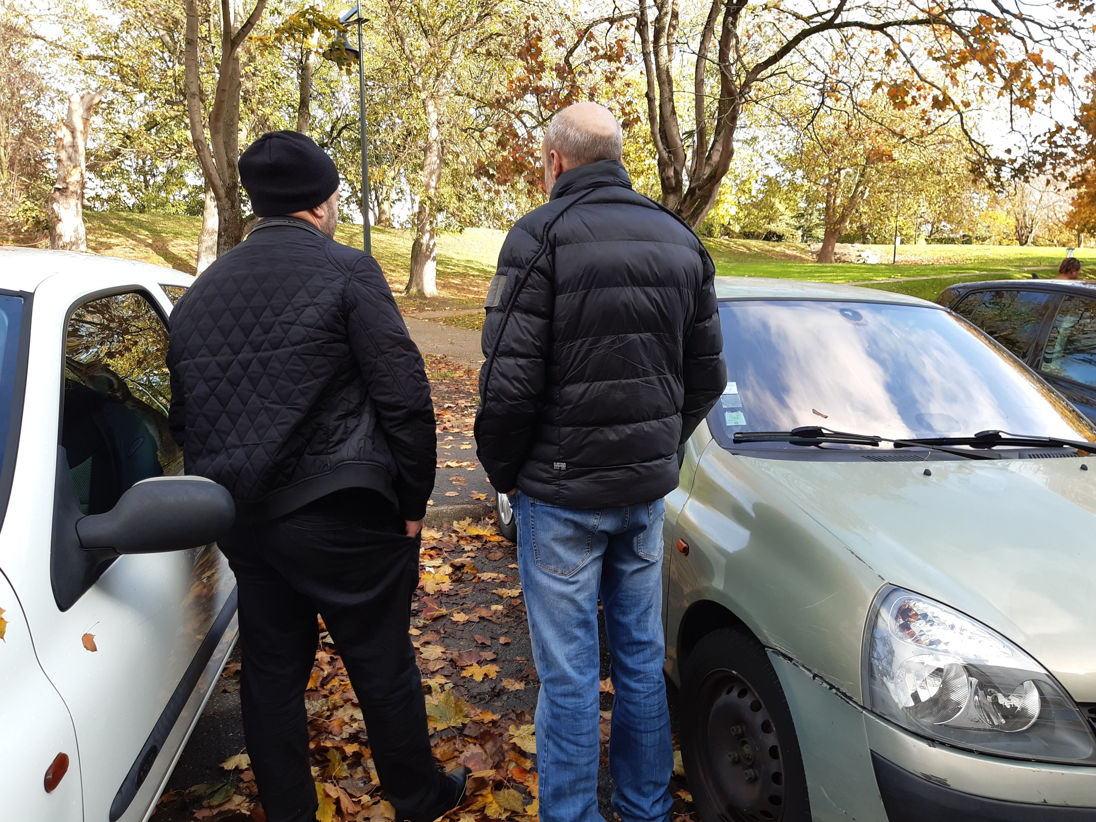 Sarcelles, le 22 novembre 2022. Karim (à gauche, ici avec un de ses voisins), chauffeur de taxi, a acheté une petite Peugeot à 1500 euros. Quand il rentre du travail tard dans la nuit, il la déplace sur la pelouse pour garer son véhicule professionnel. LP/Véronique Beaugrand
