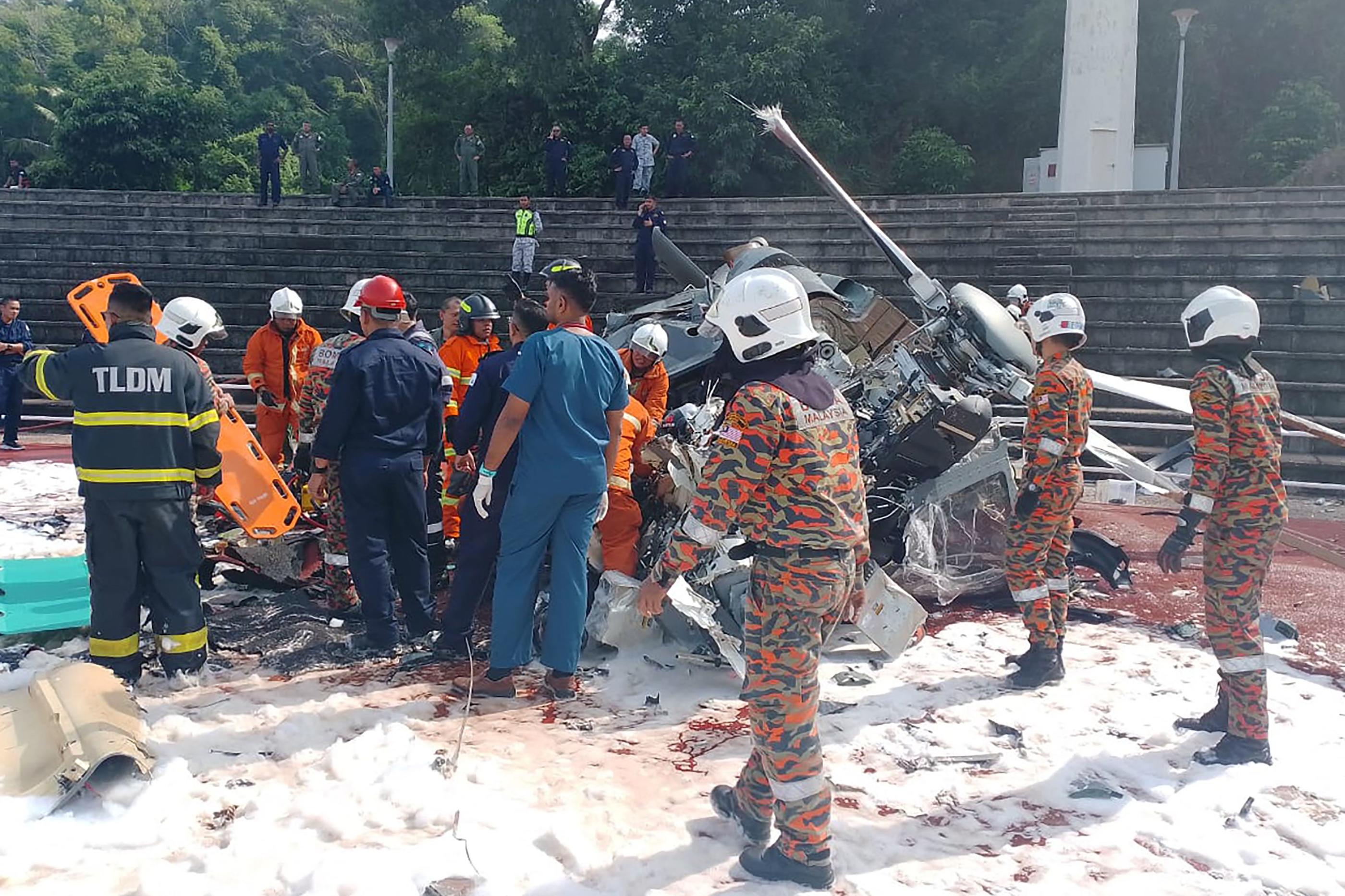 Les sauveteurs inspectant le site de l’écrasement après que deux hélicoptères militaires se sont heurtés à Lumut dans l’État malaisien de Perak. AFP/ Perak’s Fire and Rescue Department