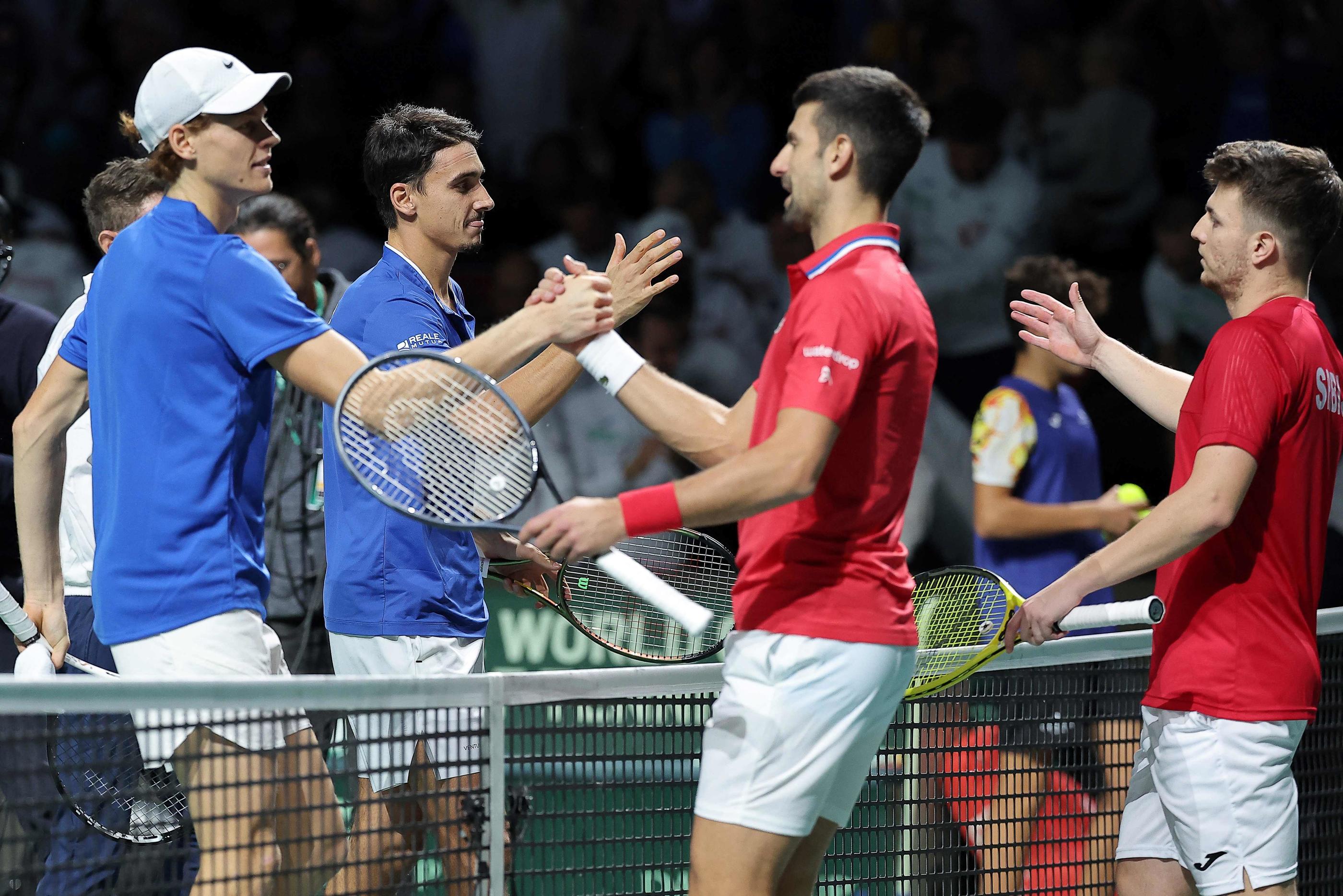 Jannik Sinner (à gauche au premier plan) est venu à bout de Novak Djokovic deux fois de suite aujourd'hui, en simple et en double. (Photo by LLUIS GENE / AFP)