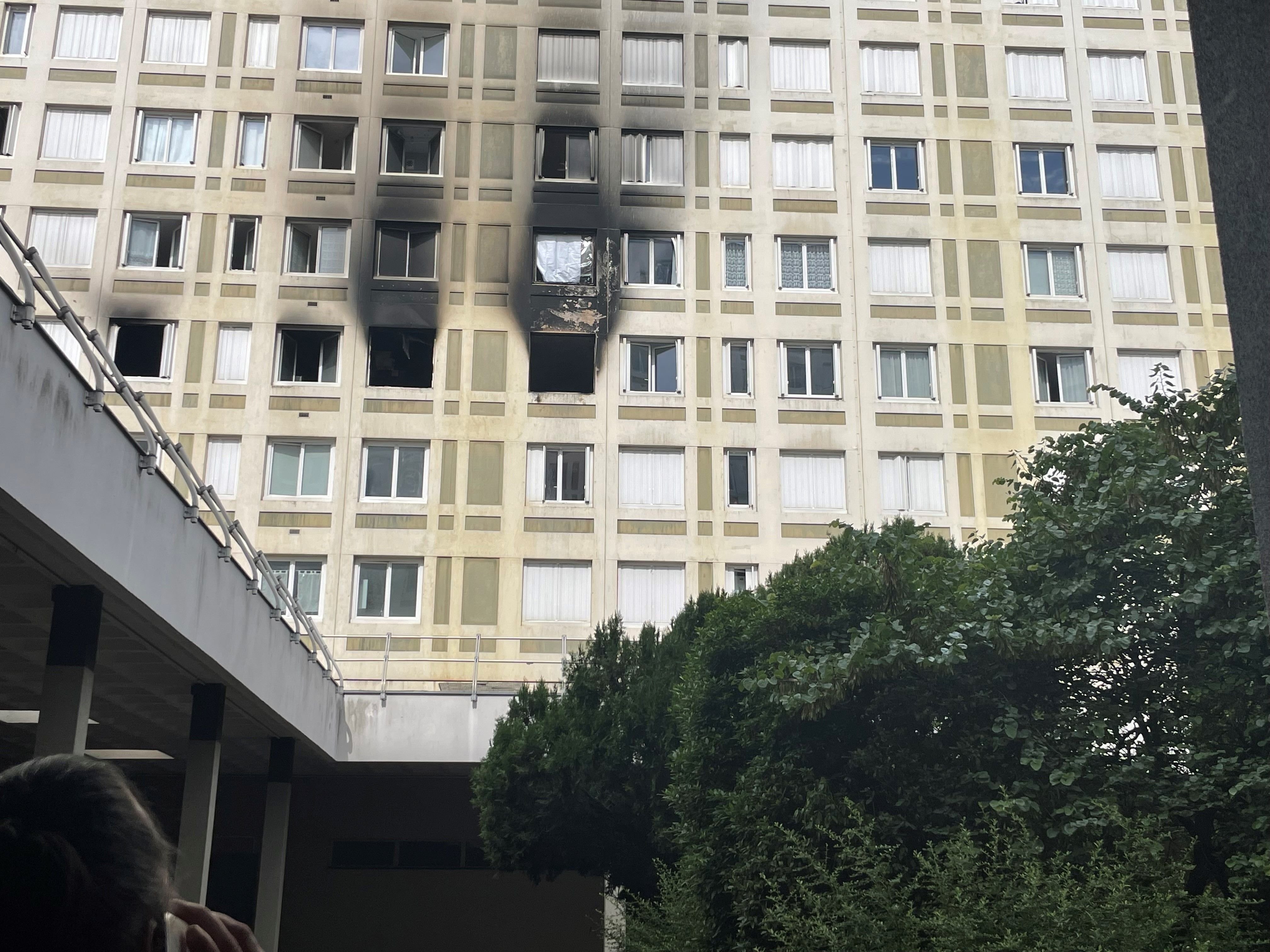 Villeneuve-Saint-Georges, le 14 juillet. Un voisin tente de vérifier avec une voisine  en vacances si son appartement a été touché par les flammes. LP/Sylvain Deleuze