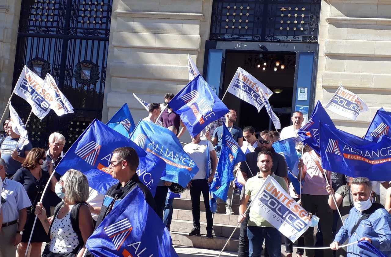 <b></b> Colombes, ce lundi après-midi. Les policiers manifestant devant la mairie arborent des drapeaux des syndicats Alliance et Unité SGP Police. 