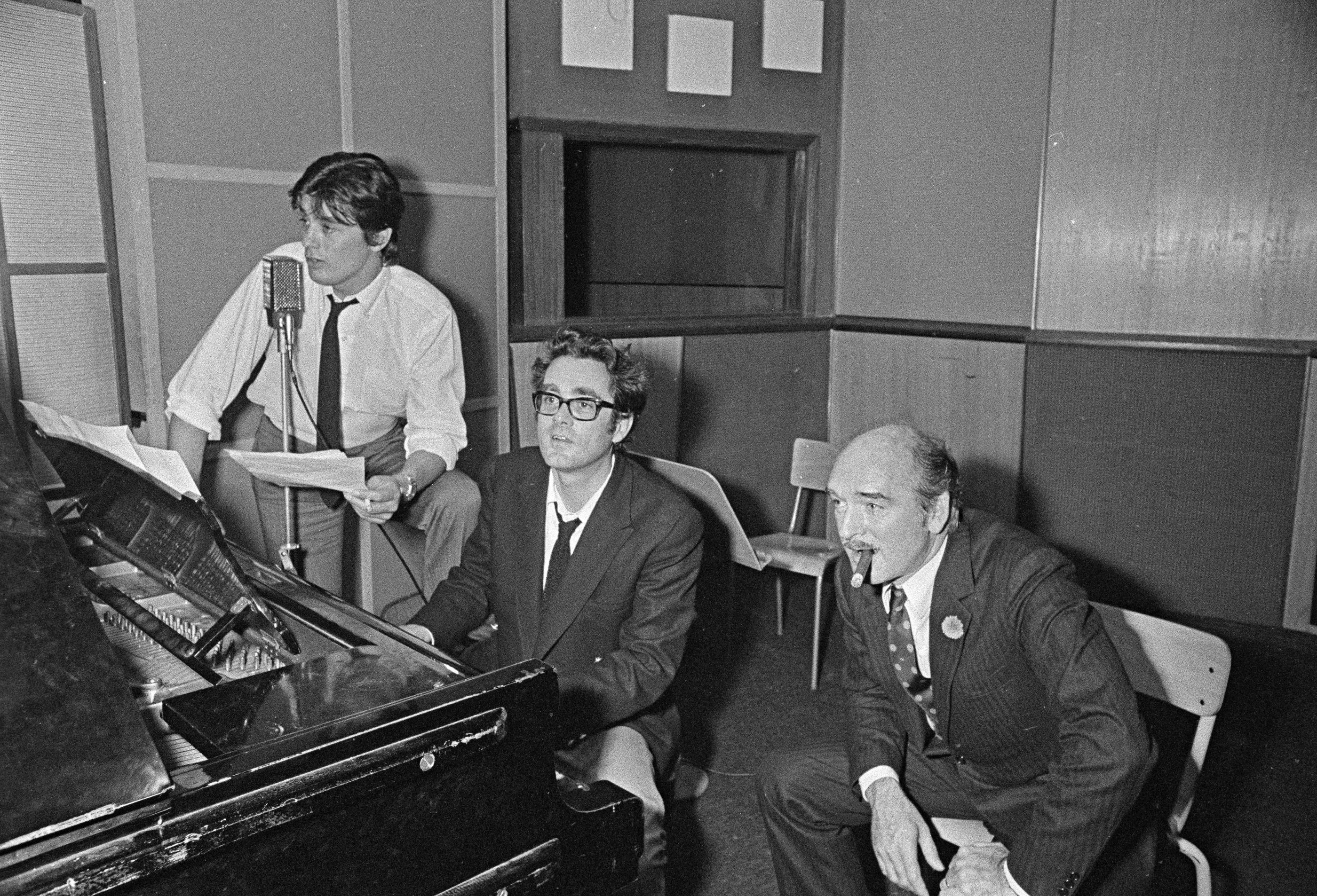 Alain Delon enregistre une chanson en compagnie de Michel Legrand (au centre), musicien et compositeur, et d'Eddie Barclay (à dr.), le 28 juin 1968. Tony Bosco/Fonds France-Soir/BHVP/Roger-Viollet