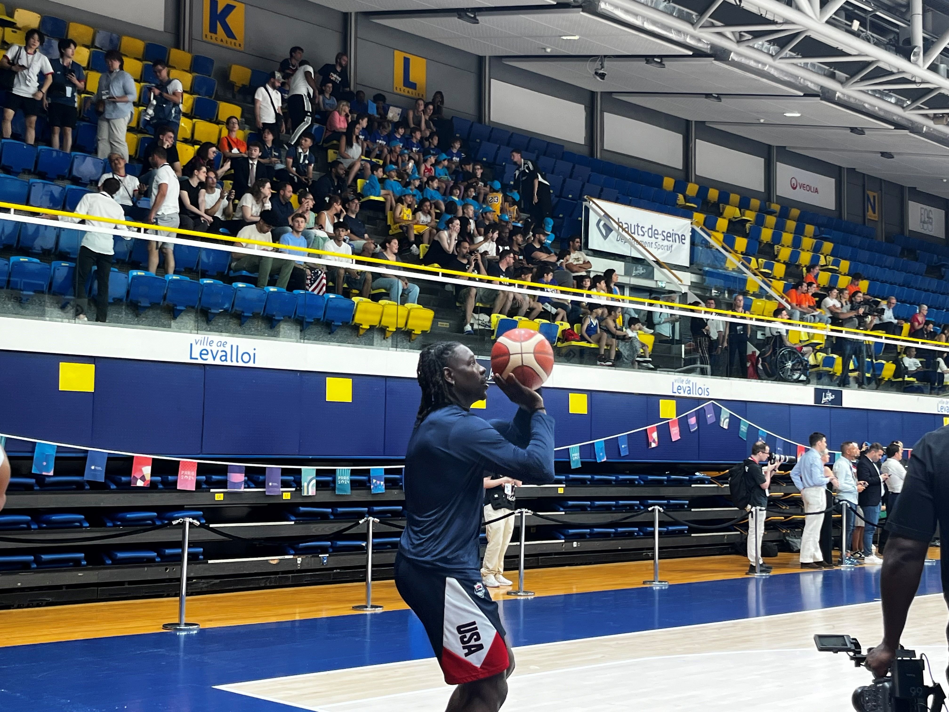 Levallois, ce mardi. Jrue Holiday se prépare à tirer devant les jeunes spectateurs d'un centre de loisirs de la ville, reconnaissables dans les gradins à leurs casquettes bleues. LP/Emma Sikli.