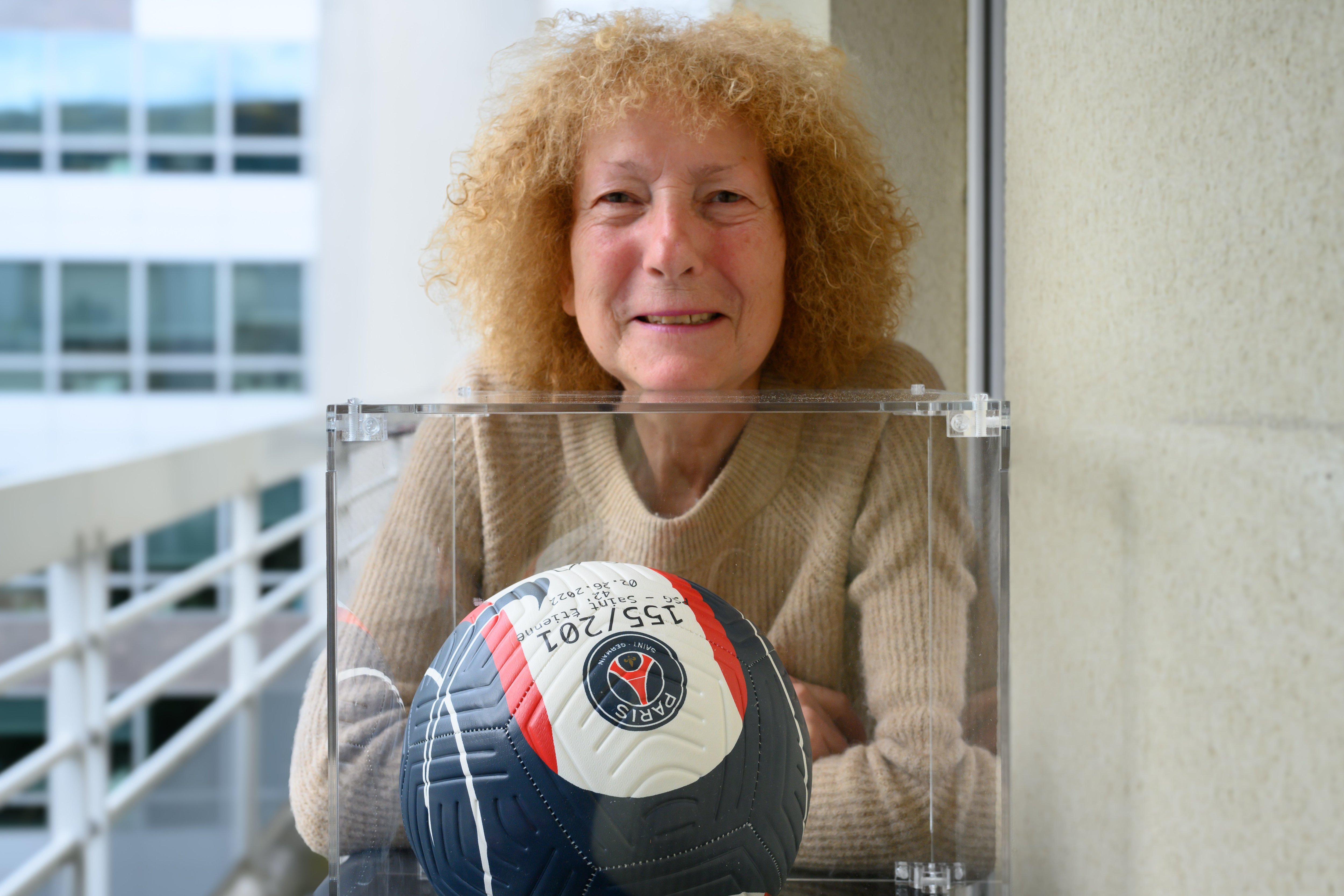 Nicole, supportrice du PSG depuis 50 ans, pose avec un ballon dédicacé par Kylian Mbappé symbolisant son 155e but avec le club en L1. Ce cadeau lui a été offert par les dirigeants parisiens afin de la récompenser pour sa fidélité. (LP/Amélie Dibon).