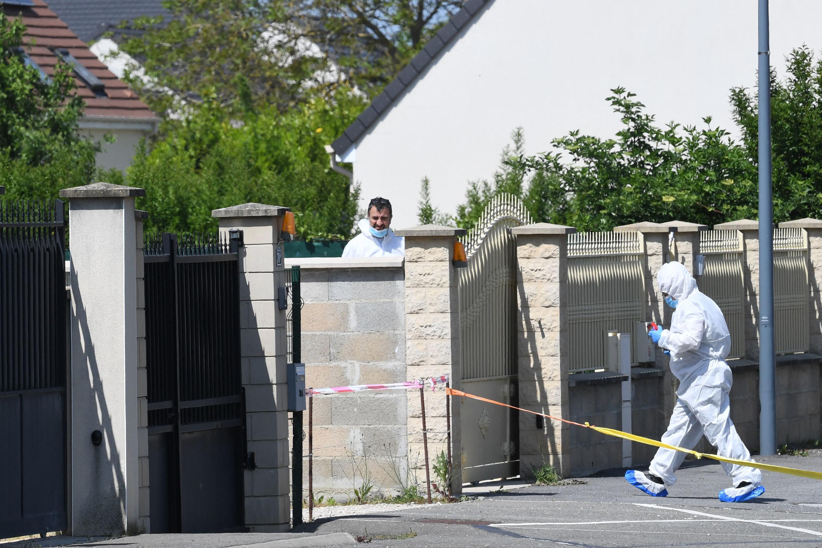 Des membres de la police scientifique devant le pavillon de la famille à Dreux dans l'est du département de l'Eure-et-Loir, où trois personnes d'une même famille ont été retrouvées mortes poignardées. AFP/JEAN-FRANCOIS MONIER