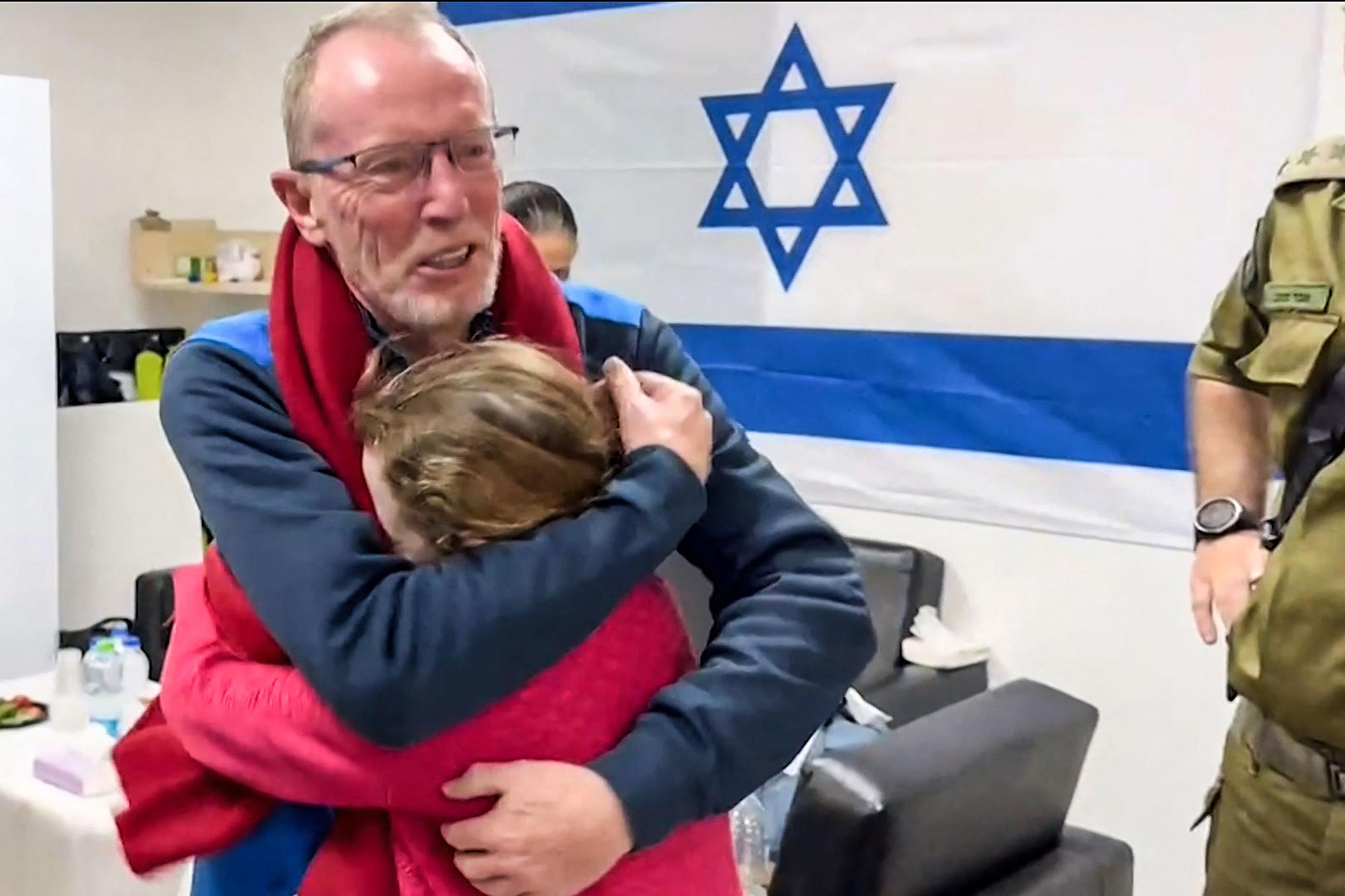 Emily Hand, ancienne otage israélienne d'origine irlandaise âgée de 9 ans, embrassant son père dans un hôpital en Israël après avoir été libérée par le Hamas, le 26 novembre 2023. AFP/Armée israélienne