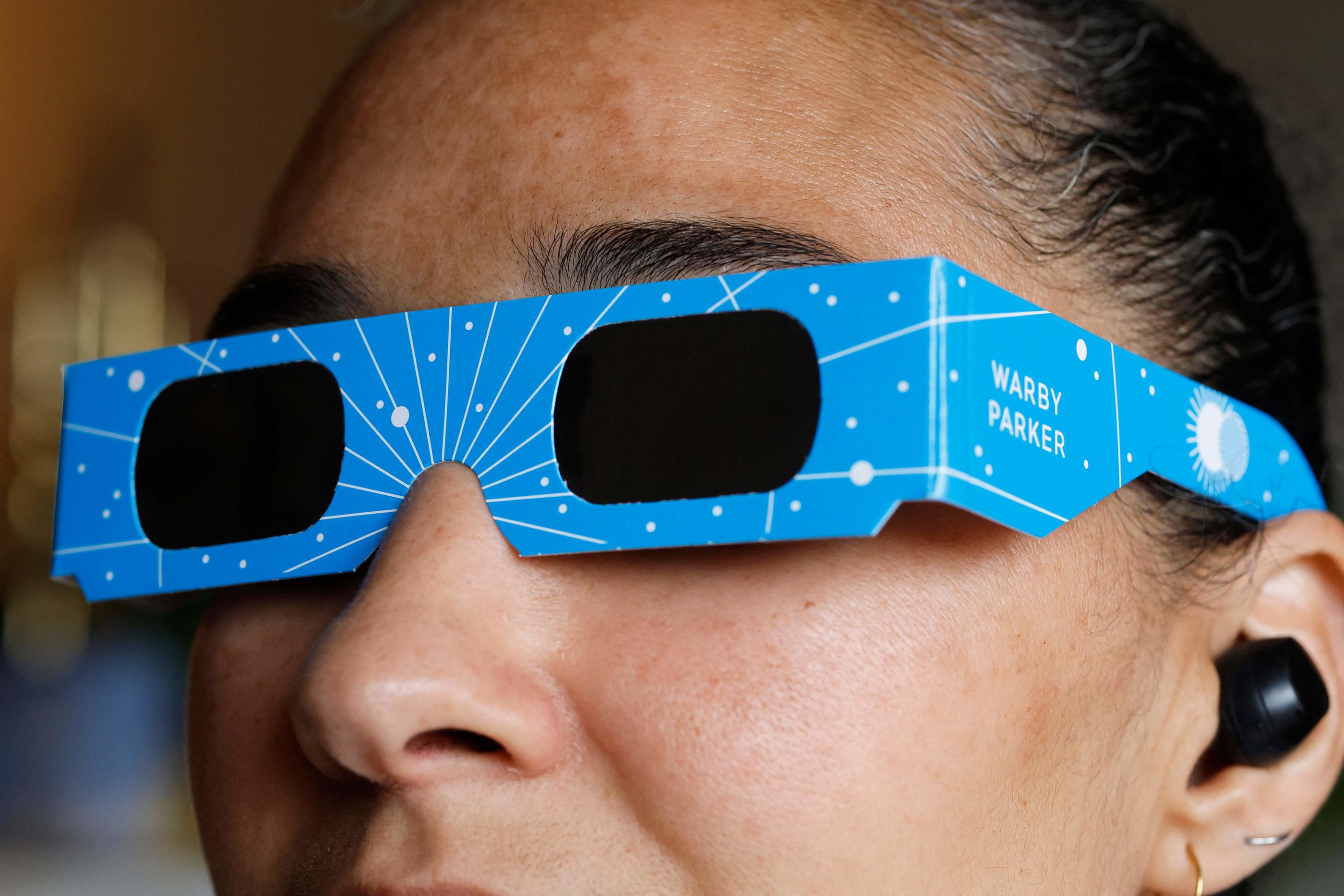 Le port de lunettes protectrices est indispensable pendant les phases partielles d'une éclipse solaire. Getty Images via AFP/ Michael M. Santiago