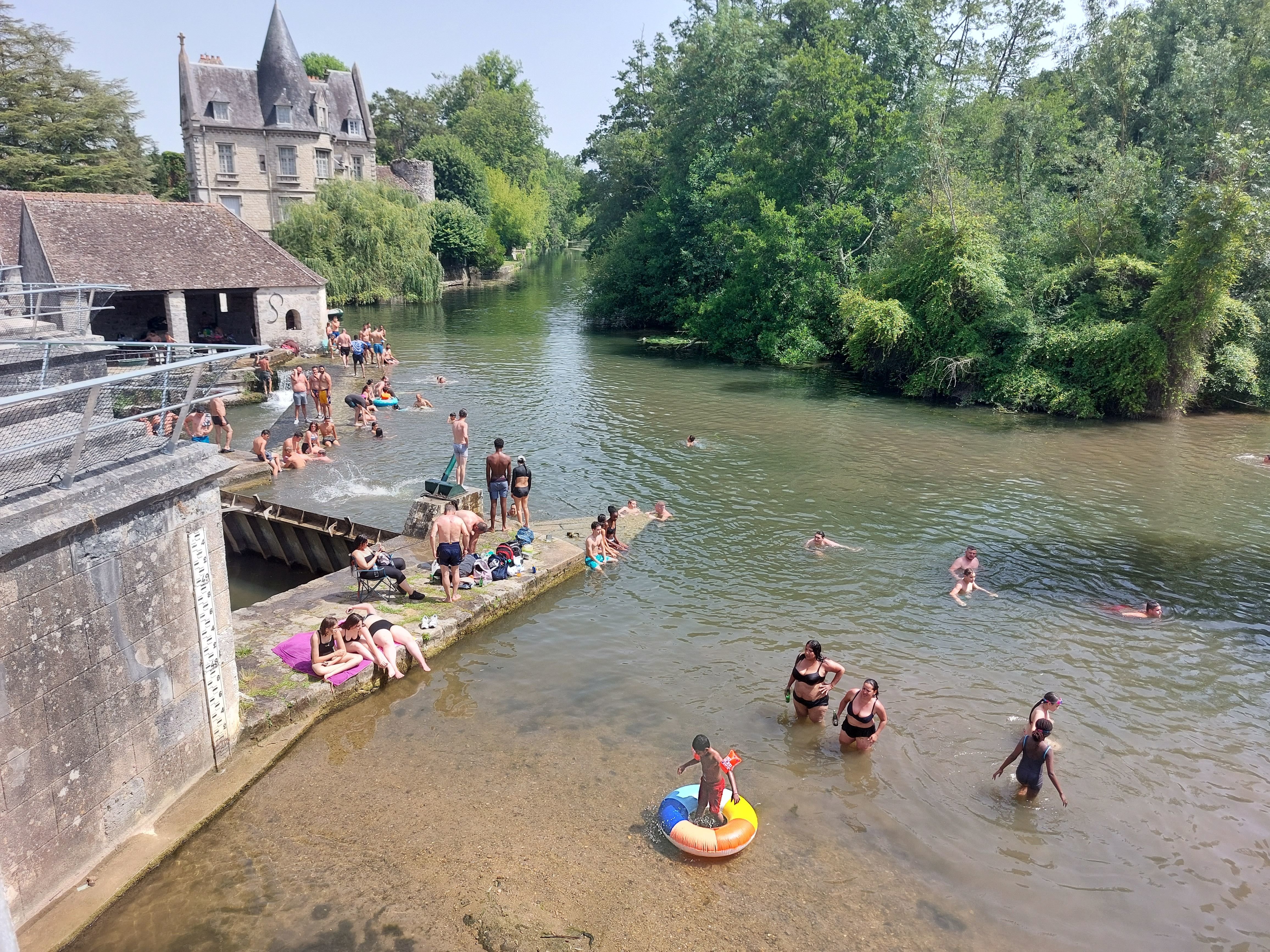 A Moret-sur-Loing, samedi 18 juin, des visiteurs venus de toute l'Ile-de-France passent outre l'interdiction de s'installer et de nager autour de ce pont classé. Des filets ont été installés pour empêcher les sauts. LP/Faustine Léo