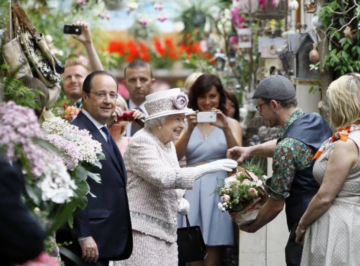 Lors de sa dernière visite officielle dans l'Hexagone, en juin 2014, la reine Elizabeth avait visité le marché aux fleurs de l'île de la Cité, rebaptisé en son honneur, en compagnie de François Hollande et Anne Hidalgo. AFP/François Mori