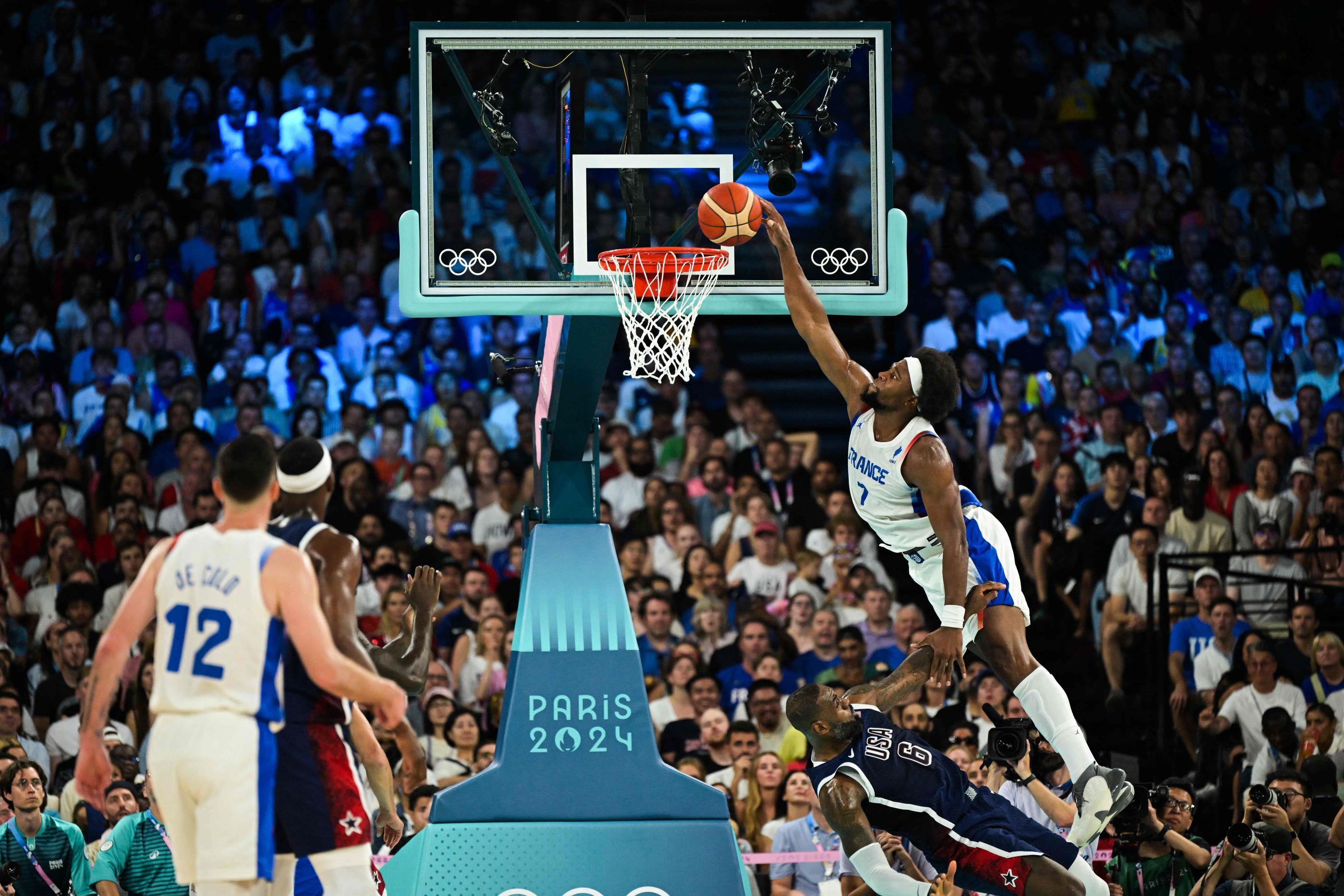 Guerschon Yabusele écrase un dunk devant LeBron James en finale des Jeux olympiques de Paris. (Photo by Damien MEYER / AFP)