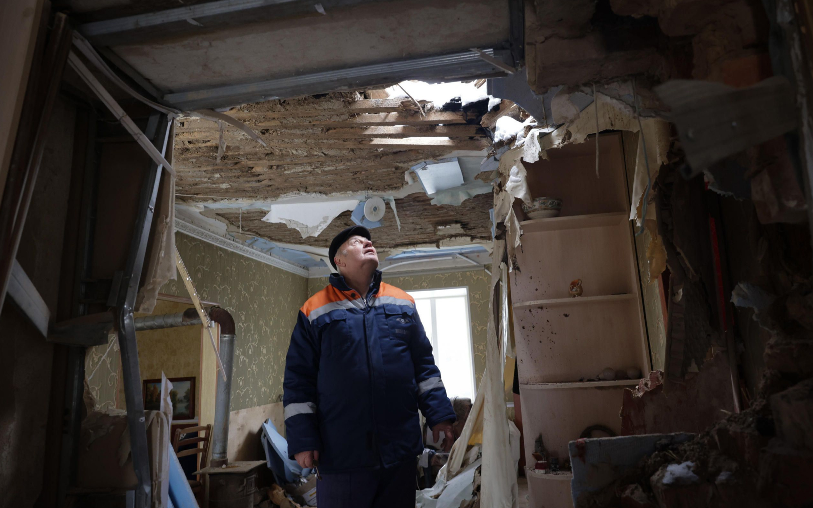 Avdiivka (Ukraine), le 15 février 2023. Anatoli observe le trou dans le toit de sa maison, une roquette est tombée en pleine nuit dans son salon, alors qu'il dormait avec son fils dans la pièce d'à côté. LP/Philippe de Poulpiquet