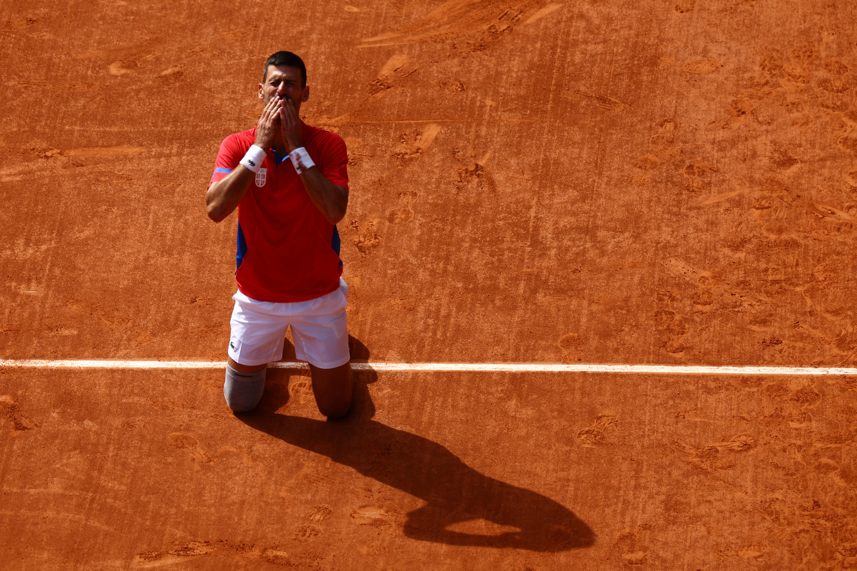 Paris, dimanche 4 août. Novak Djokovic peut s'agenouiller sur la terre battue de Roland-Garros, il vient de remporter le dernier titre qui lui manquait. REUTERS/Edgar Su