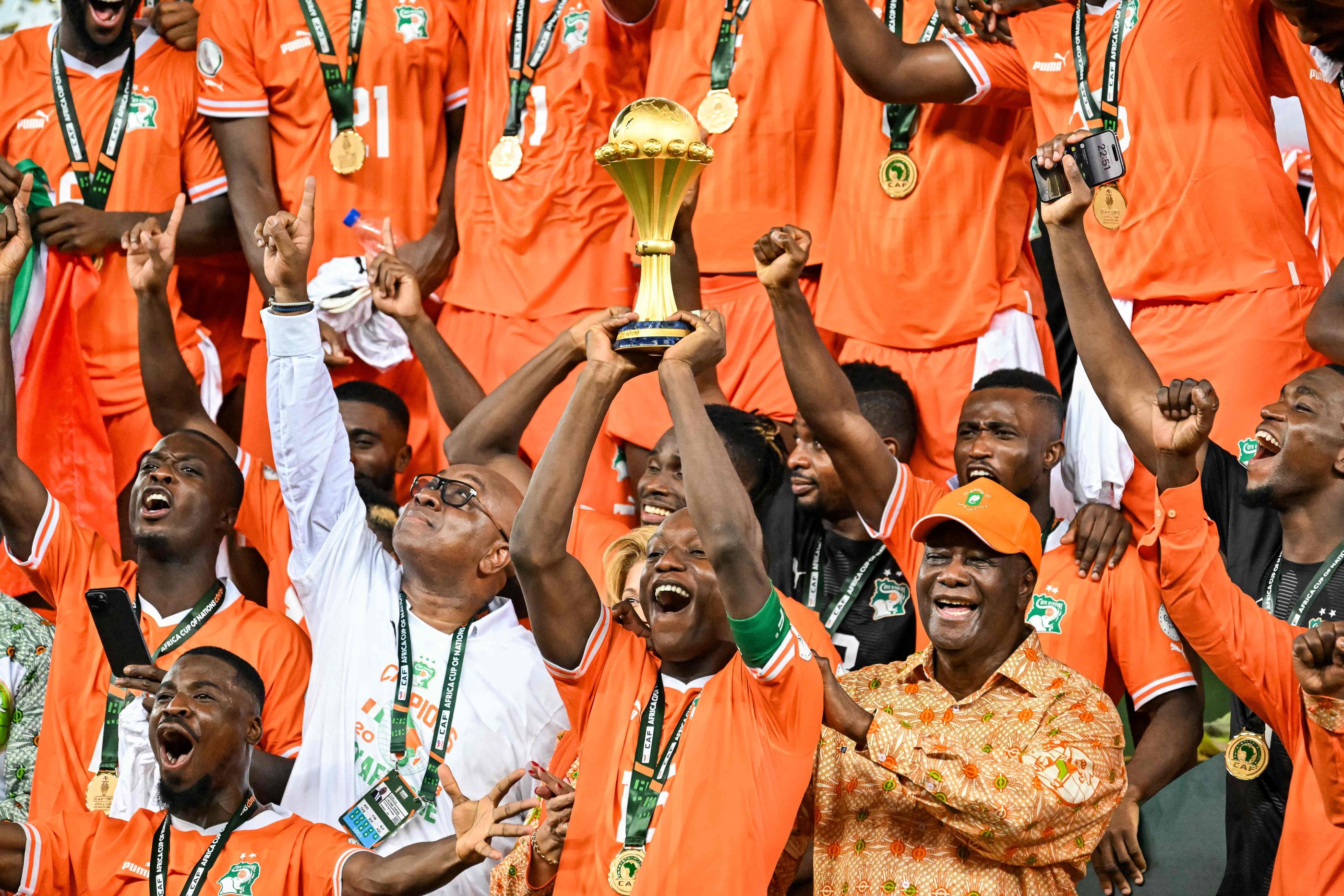 Max Alain Gradel, juste à côté du président ivoirien Alassana Ouattara, soulève le trophée (Photo Sia KAMBOU / AFP)