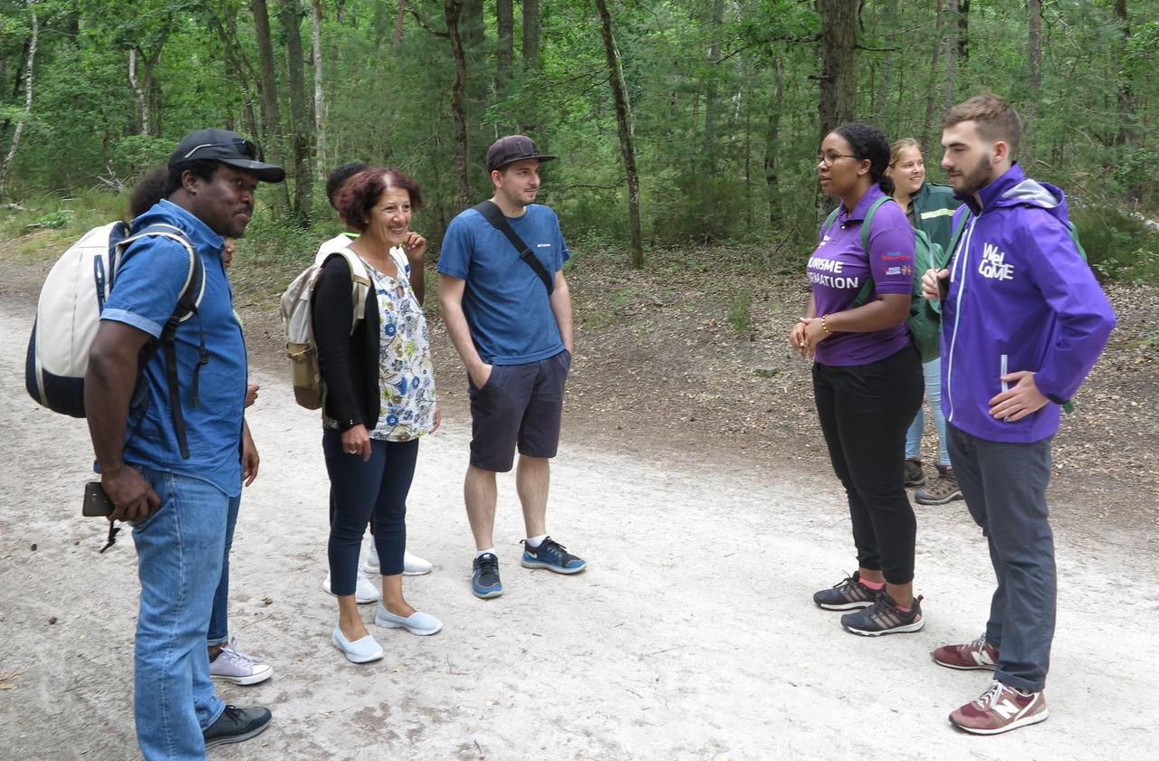 <b></b> Forêt de Fontainebleau, juillet 2020. Camille Zengo et Pierre Lacroix (en tenue violette), les deux volontaires du tourisme, orientent des visiteurs venus de Lorraine dans la forêt des Trois Pignons. 