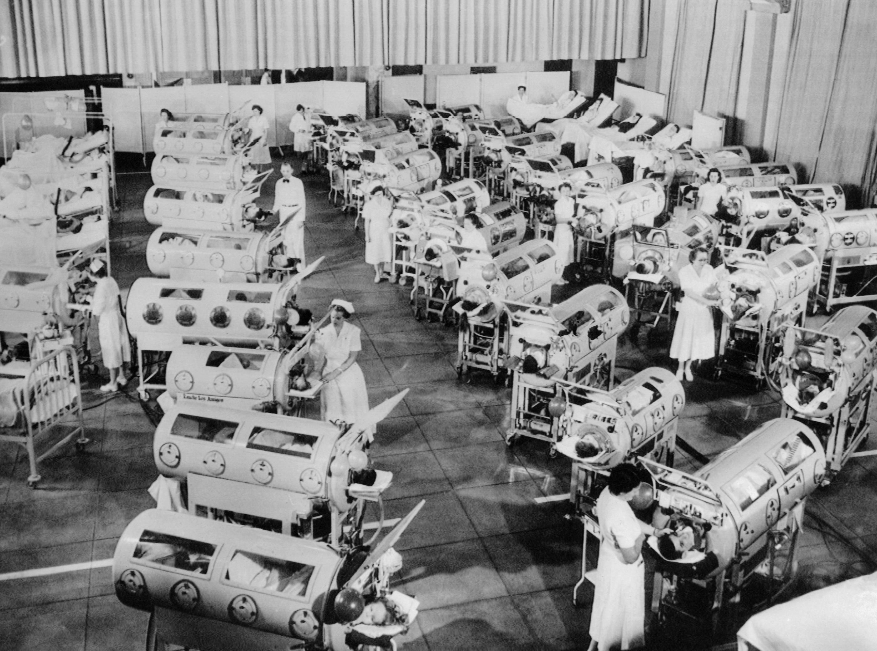 Des infirmières s'affairent dans une salle remplie de patients atteints de poliomyélite et pris en charge dans des poumons d'acier, au centre respiratoire Rancho Los Amigos, à Hondo (Californie), en 1953. Archives CSU/Collection Everett
