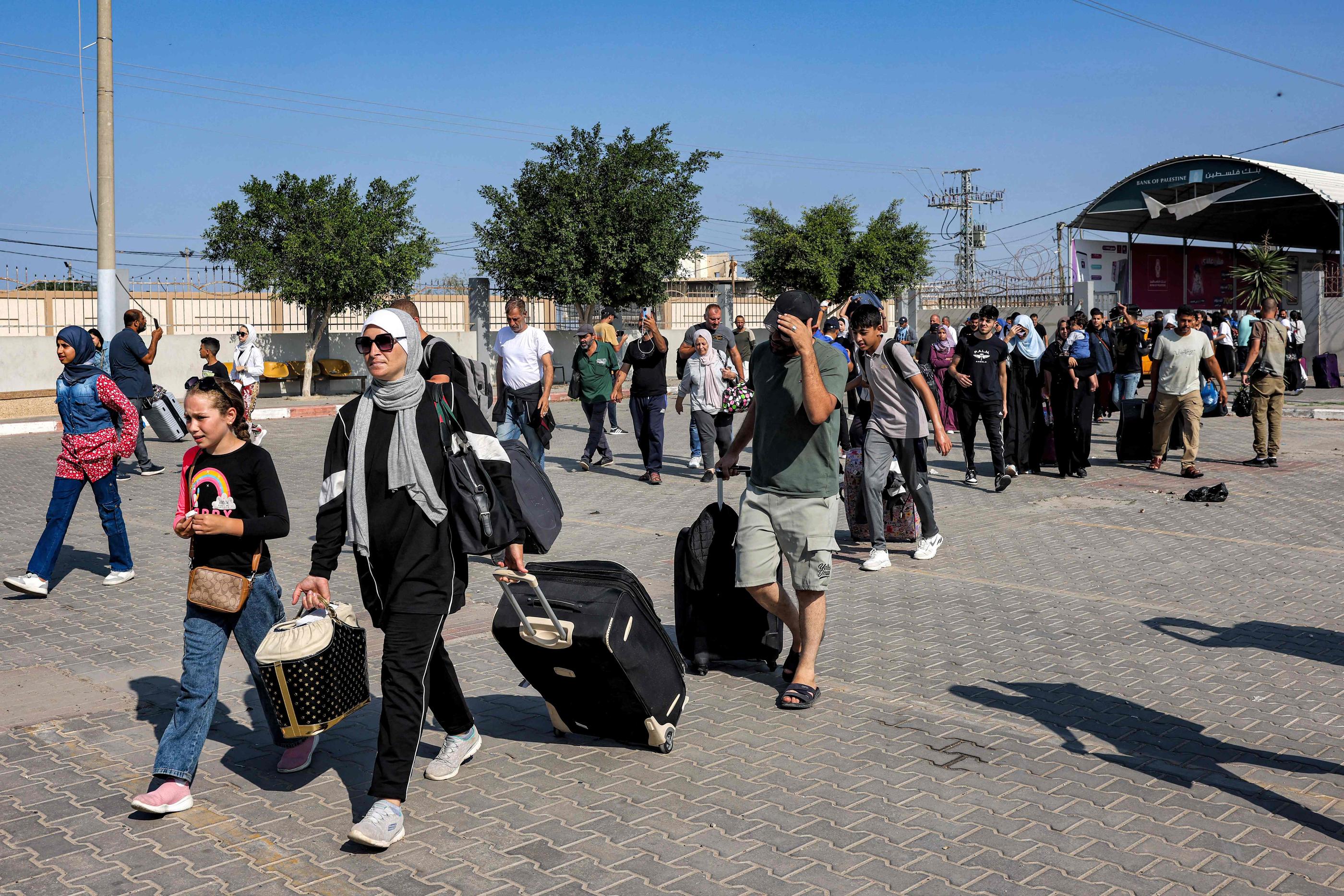 Des personnes entrent dans le poste frontière de Rafah, dans le sud de la bande de Gaza, avant de passer en Égypte, le 1er novembre 2023. AFP/Mohammed Abed