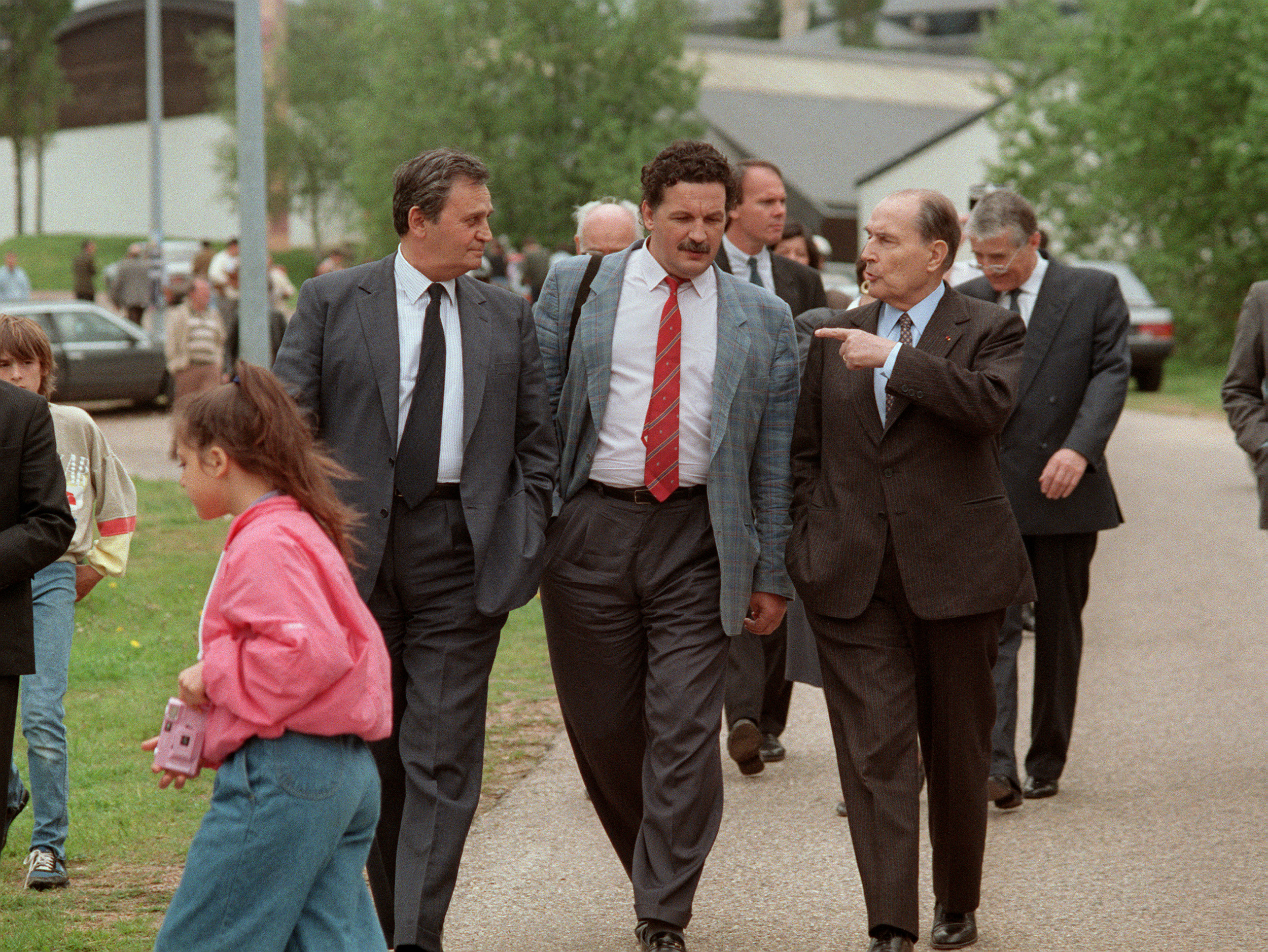 François Mitterrand, candidat socialiste à l'élection présidentielle, discute avec son fils Jean-Christophe, le 8 mai 1988, dans les rues de Château-Chinon sous le regard de l'acteur Roger Hanin, beau-frère du président. AFP/GERARD MALIE