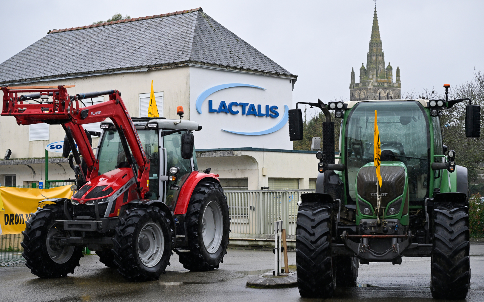 Des agriculteurs manifestent devant le siège social de Lactalis, le 21 février 2024, à Laval (Mayenne), pour dénoncer les pratiques du géant de l’industrie laitière et réclamer une meilleure rémunération des éleveurs. AFP/Damien Meyer