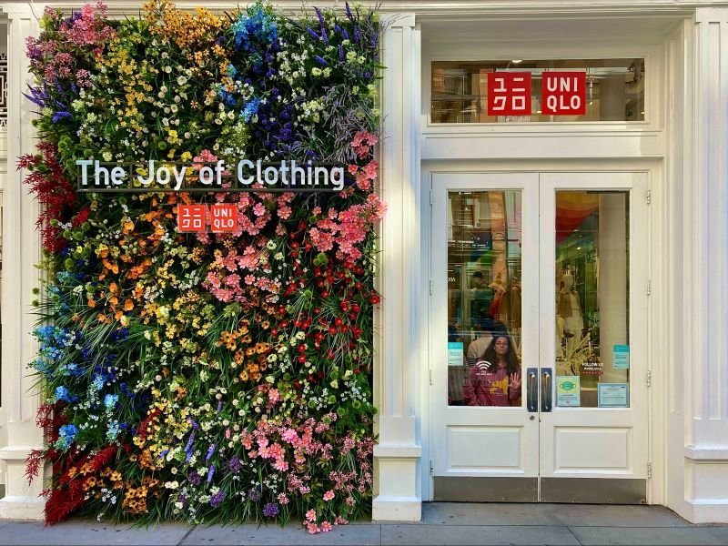 Quartier de Soho (New York, États-Unis). La boutique de vêtements Uniqlo est décorée d'une façade de fleurs multicolores et artificielles. DR