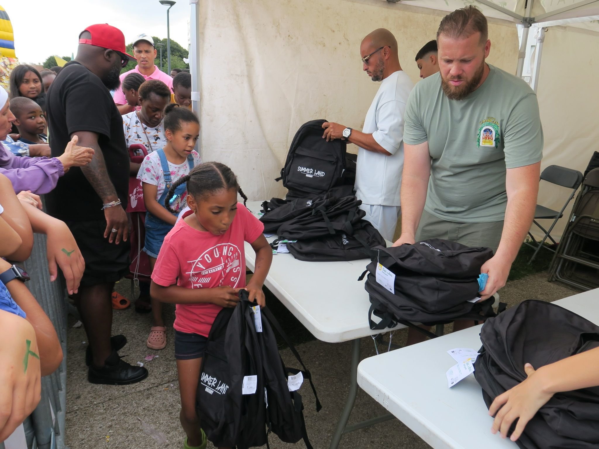 Grigny, ce samedi. Il fallait prendre un ticket et faire la queue pour récupérer un sac à dos rempli de fournitures scolaires. LP/S.M.