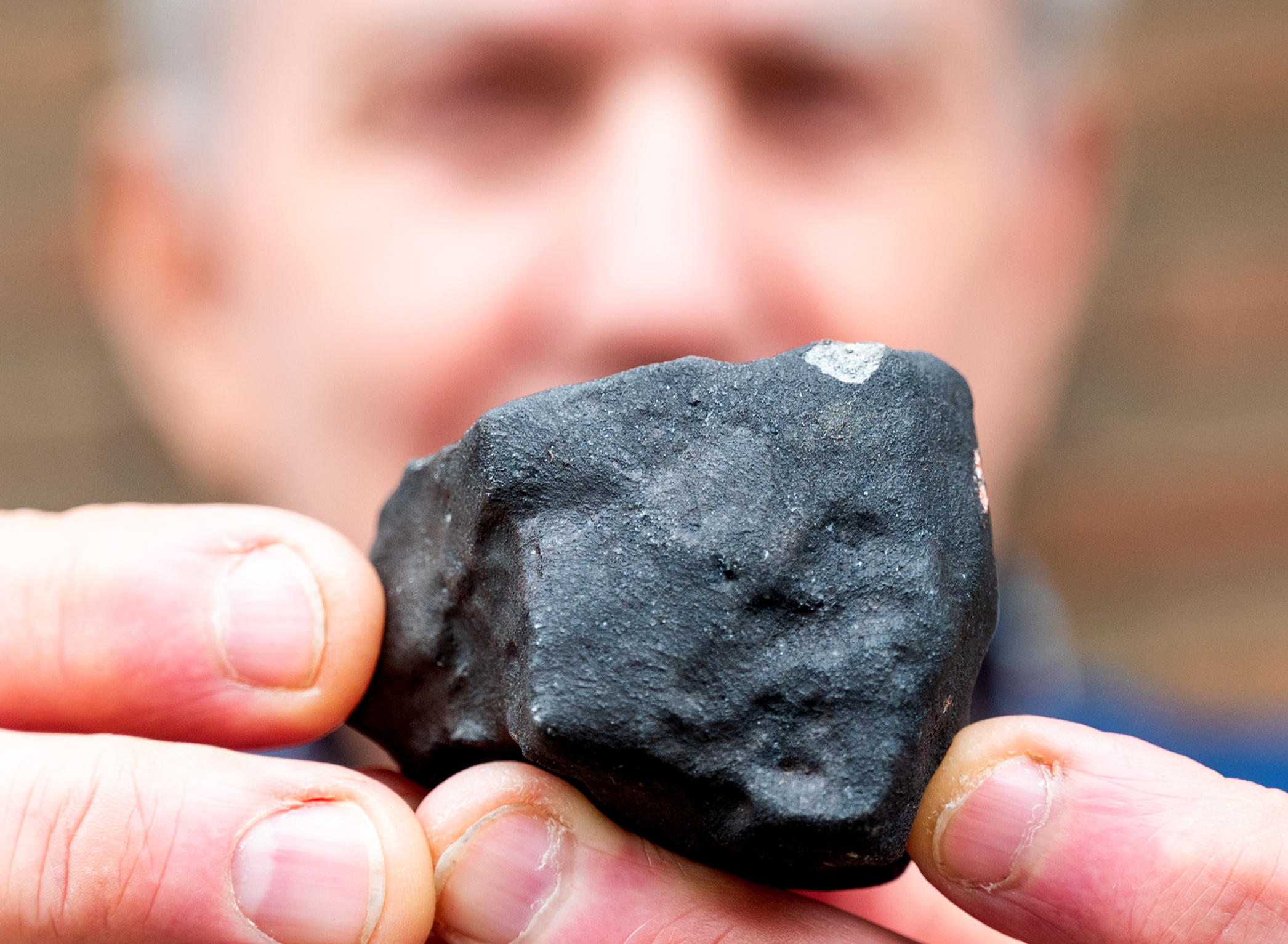 Un homme présentant un bout de météorite retrouvé dans son jardin à Schleswig-Holstein, Elmshorn, en Allemagne, le 28 avril 2023 (illustration). DPA/Daniel Bockwoldt - Photo by Icon sport