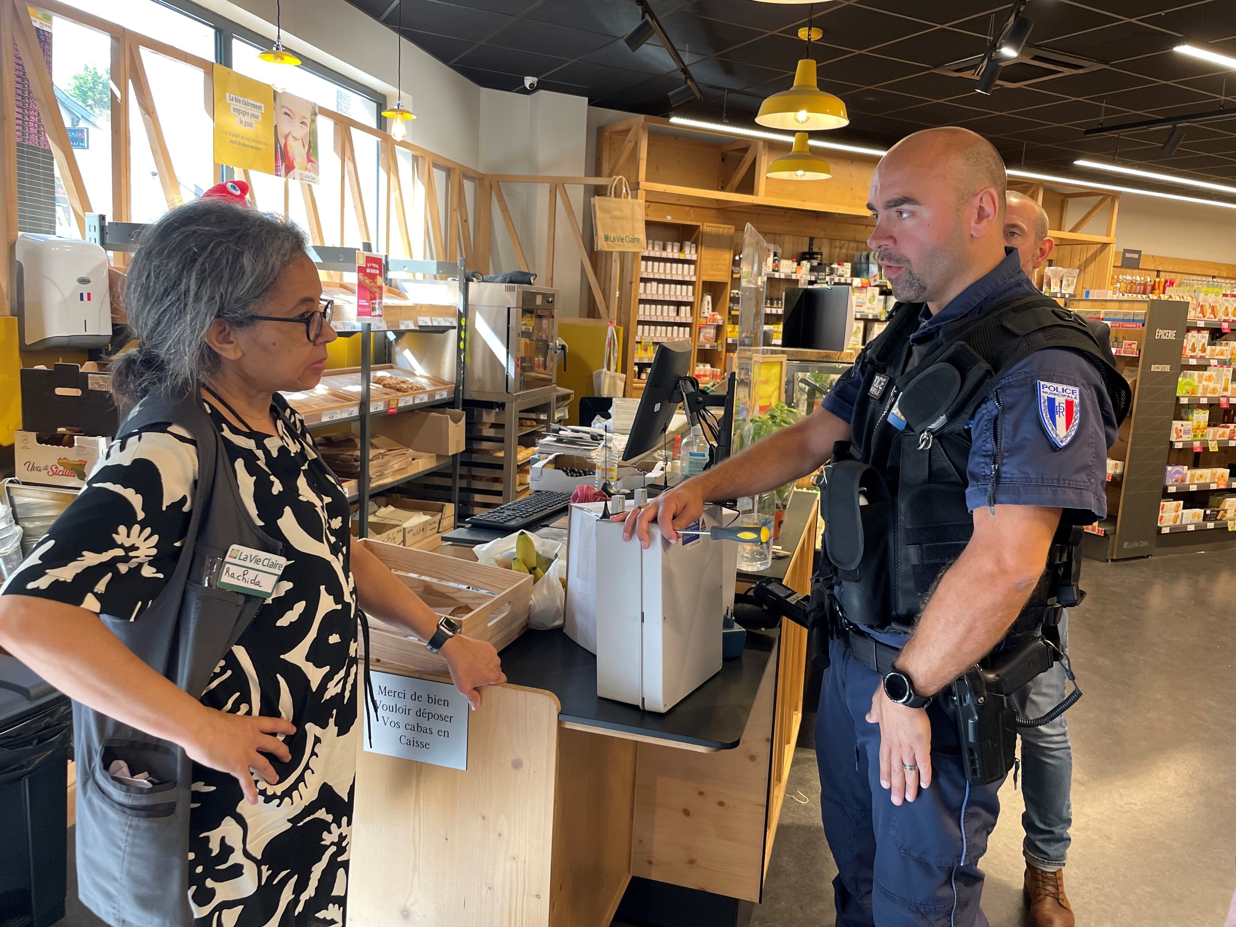 Villiers-sur-Marne, le 11 juillet 2024. Benjamin Couteau, le chef de la police municipale, présente le kit d'alerte avec un boitier et deux télécommandes, à Rachida Madkouri, la patronne de la boutique La Vie Claire. LP/Sylvain Deleuze