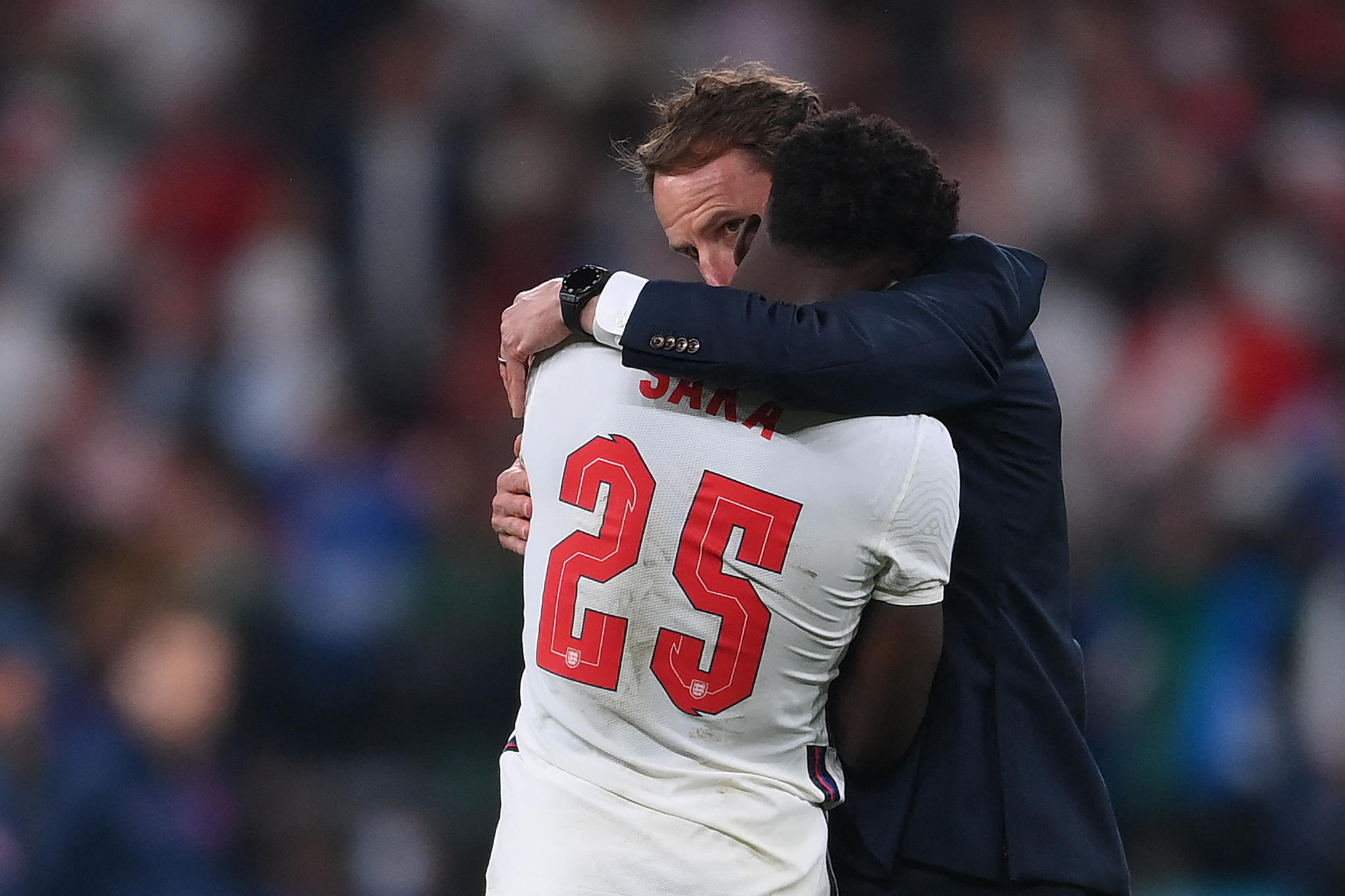 Après son échec aux tirs au but, Bukayo Saka, en larmes, est consolé par son sélectionneur Gareth Southgate. AFP/Pool/Laurence Griffiths