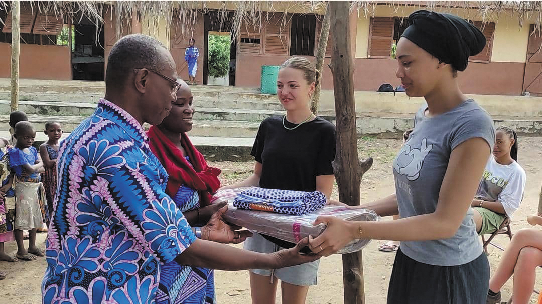 L'équipe d'Huma Omnes remet des tissus au directeur de l'école de Gilgal (Togo), pour la confection de nouveaux uniformes scolaires.